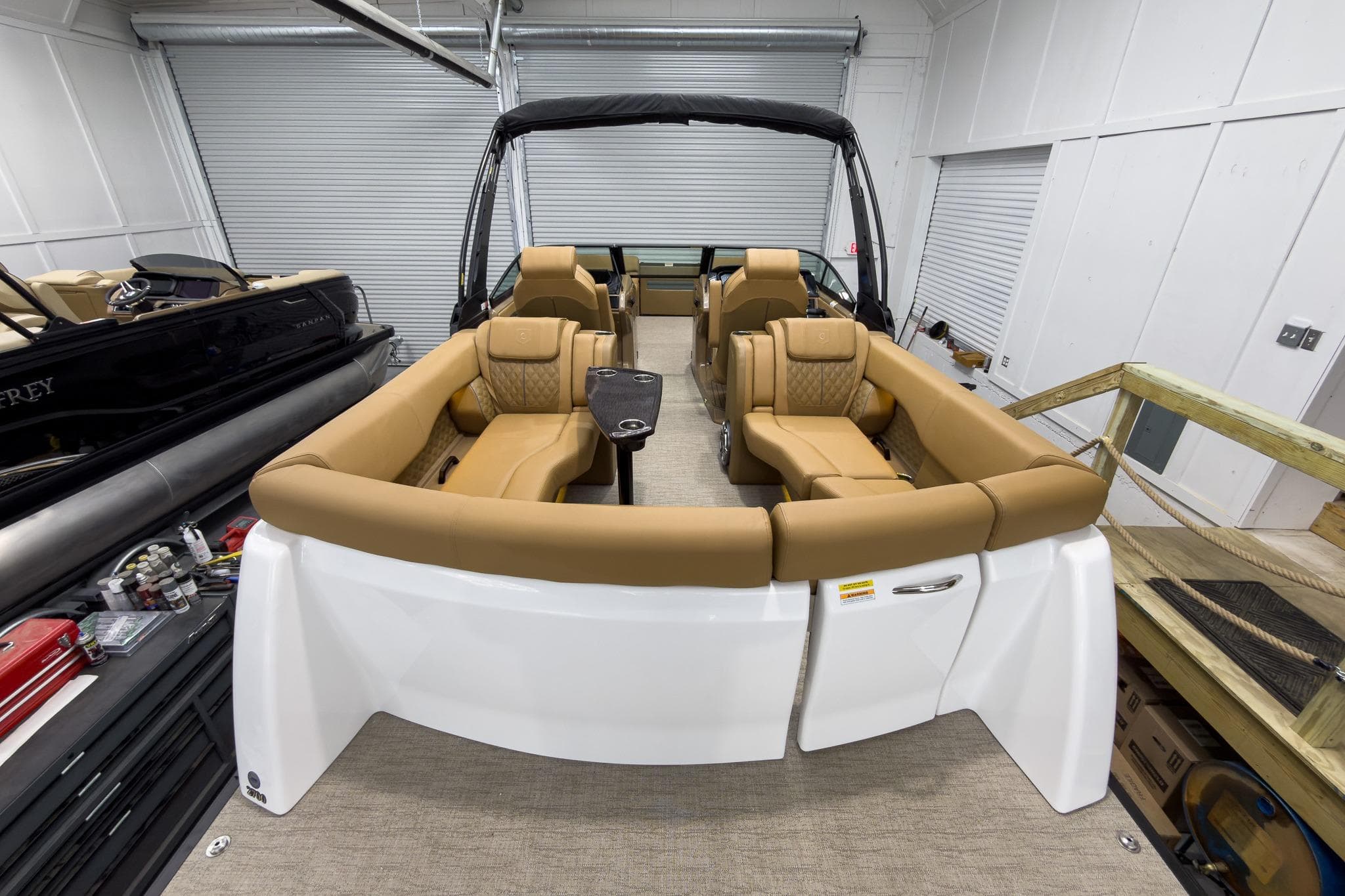 2026 Godfrey Sanpan 27' Tritoon with luxurious tan seating in a showroom.