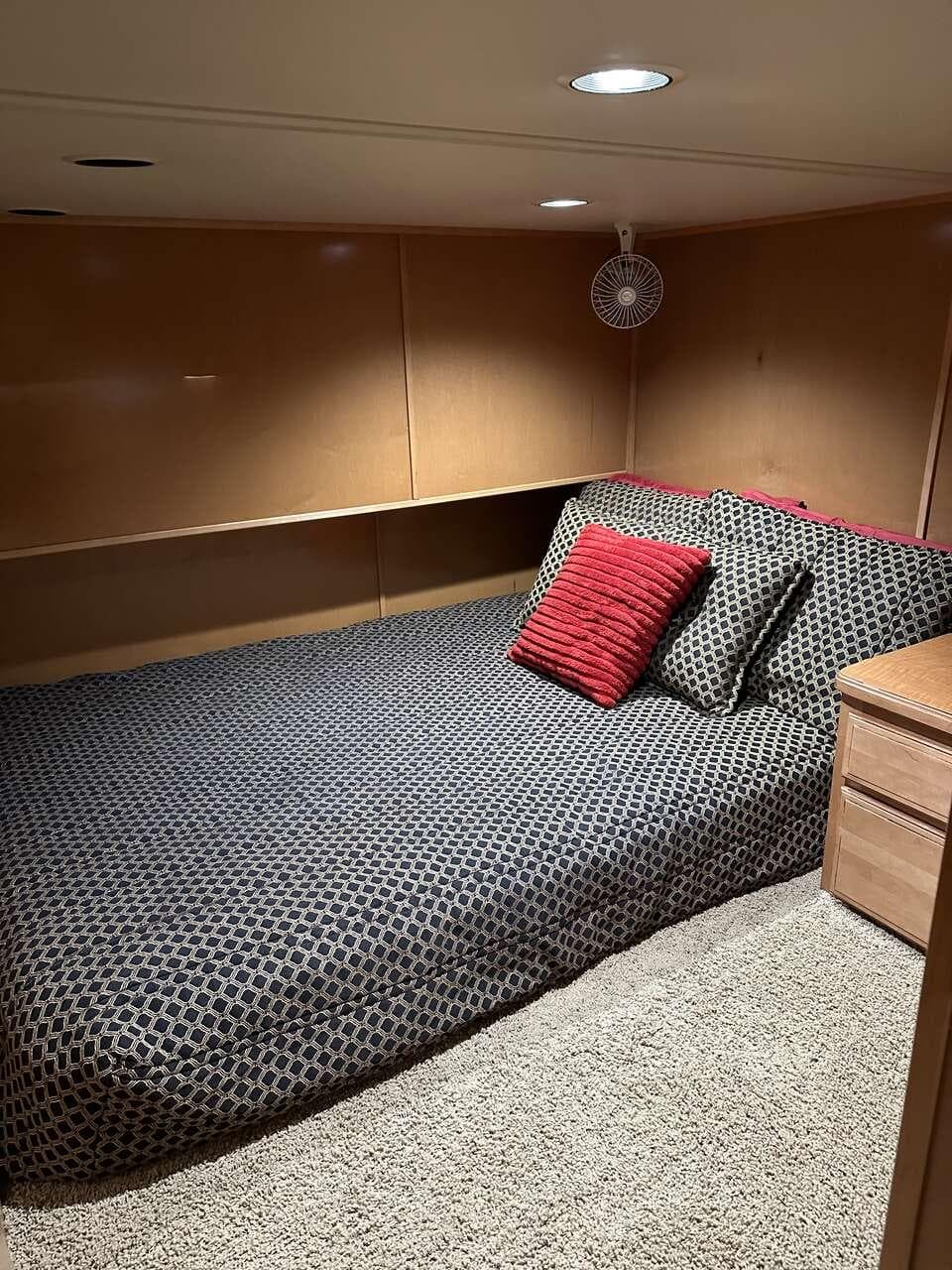 Cozy bedroom in 2005 Sumerset Top Hat houseboat with modern decor and plush bedding.