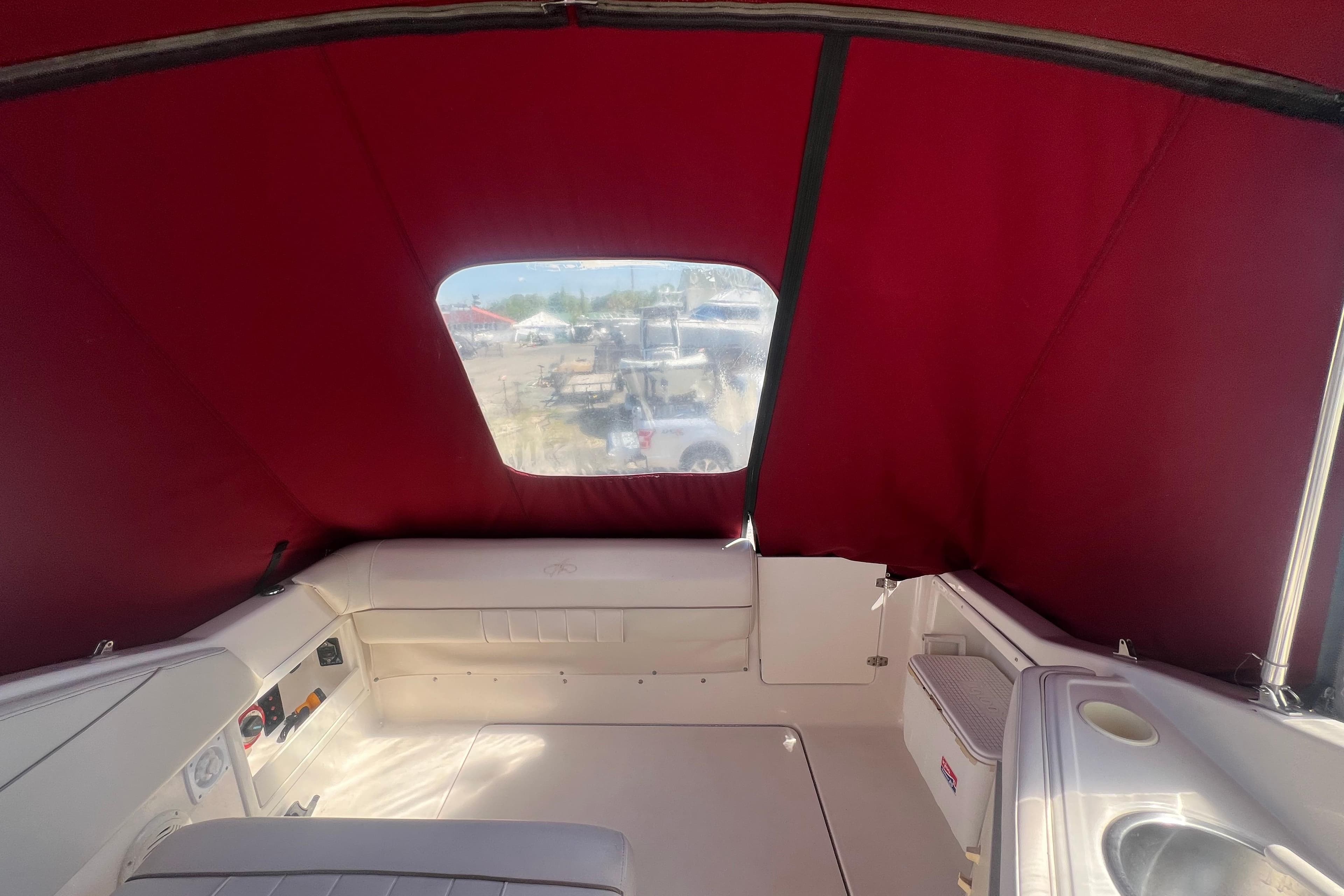 Interior view of a 2002 Monterey 262 Cruiser boat with red canopy and seating area.