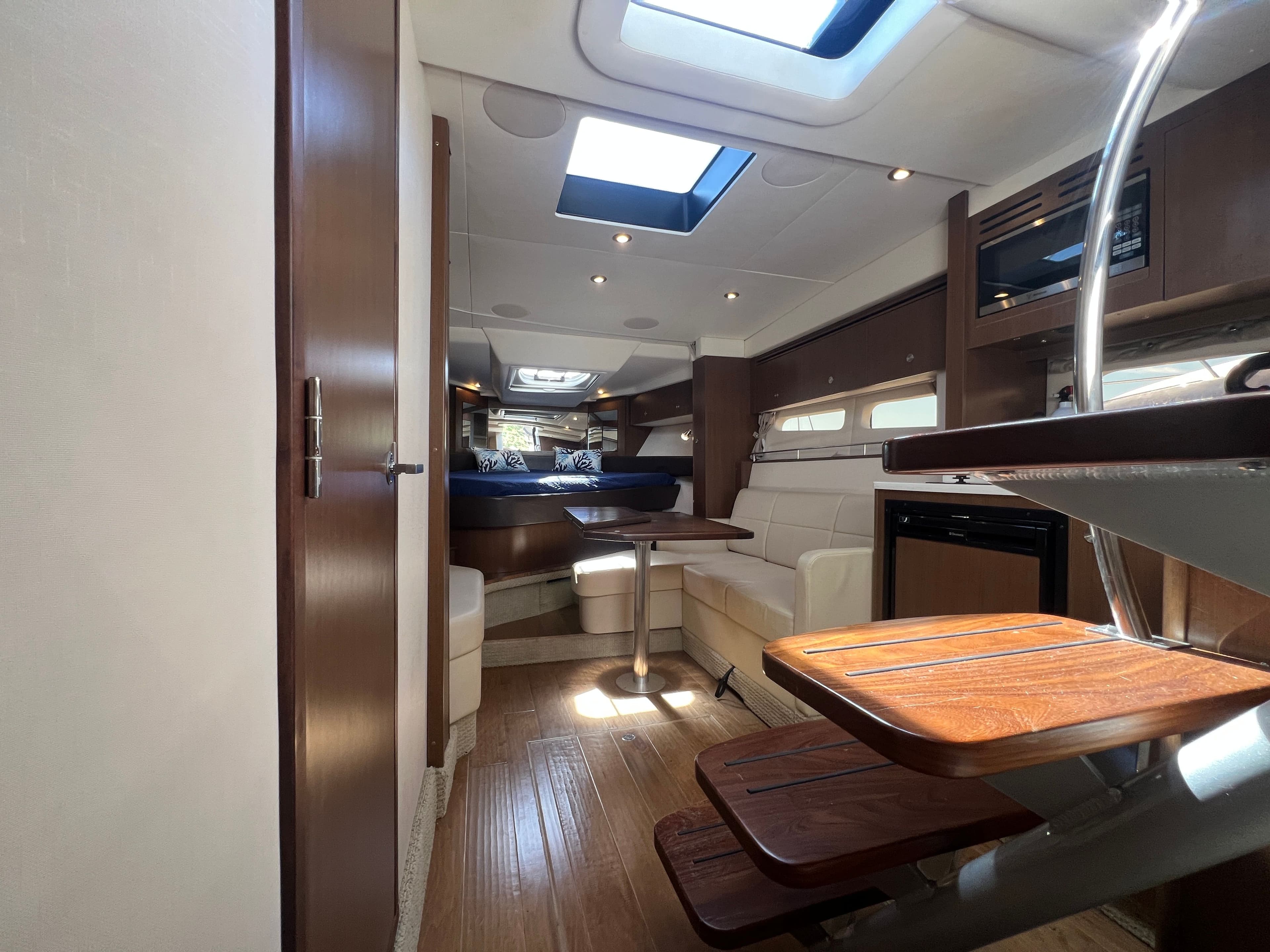Interior of 2018 Sea Ray Sundancer 350 Coupe with wood flooring and leather seating.