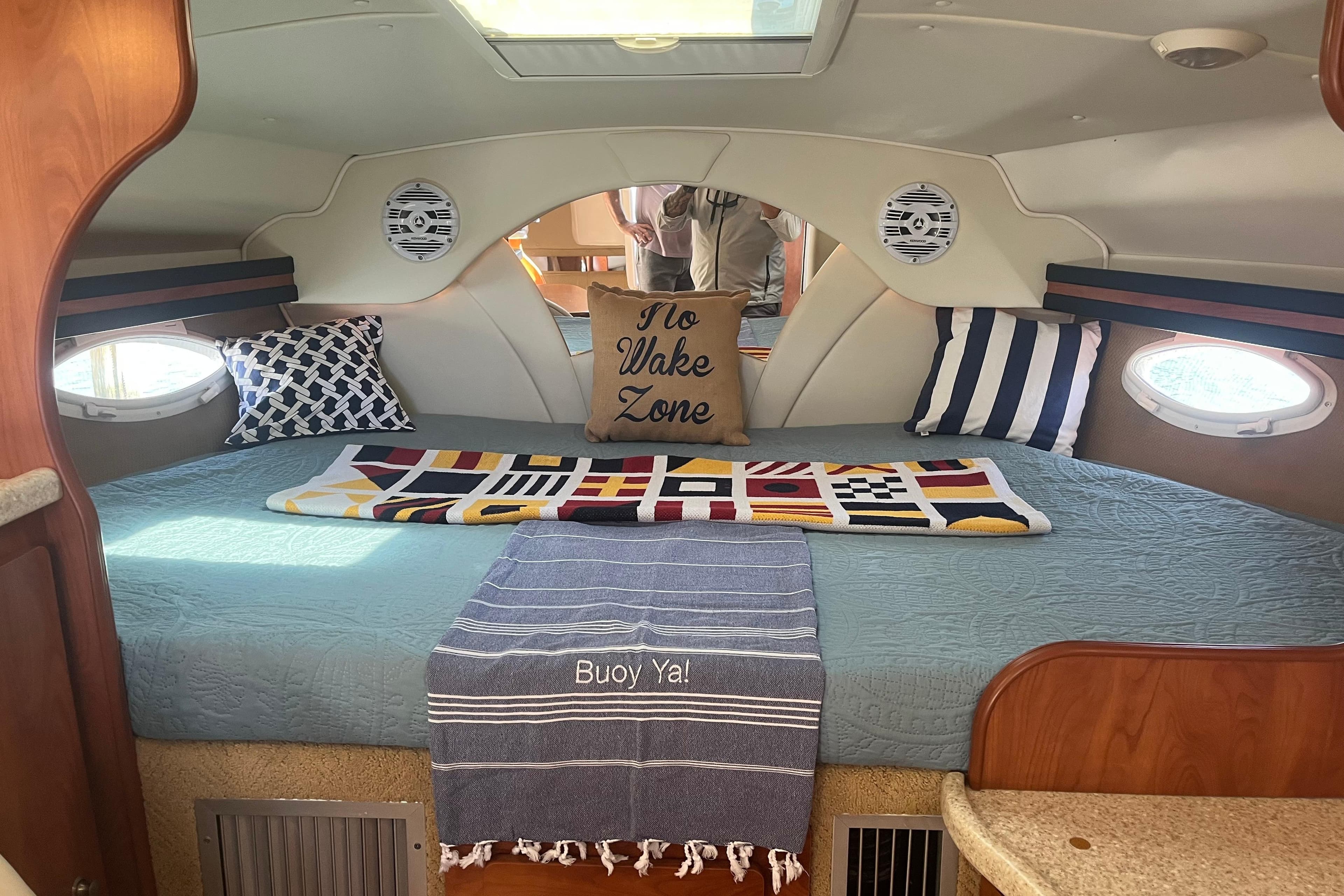 2007 Rinker 320 Express Cruiser cabin with nautical decor and cozy bedding.
