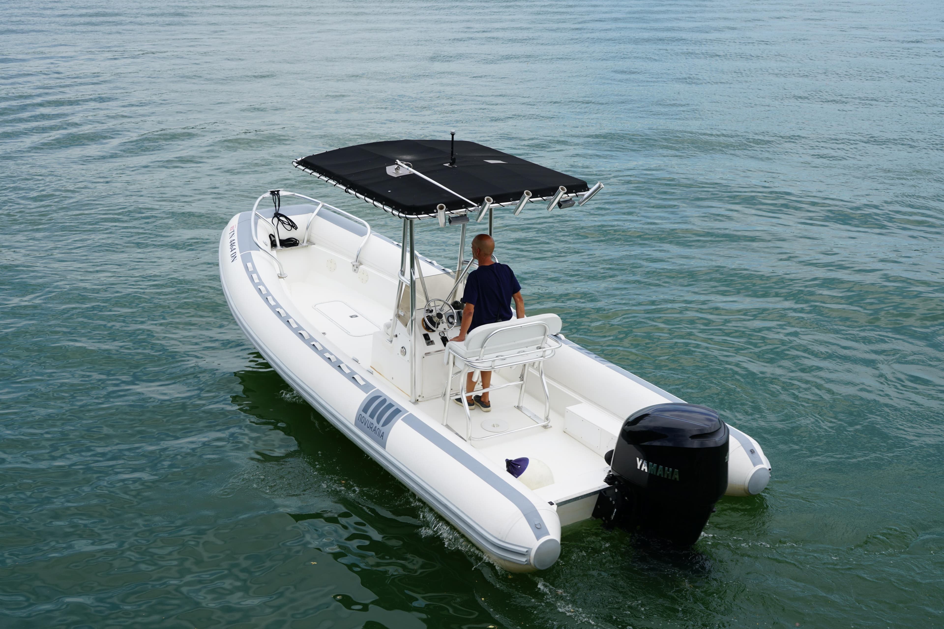 2003 Novurania 24 boat with canopy cruising on water.
