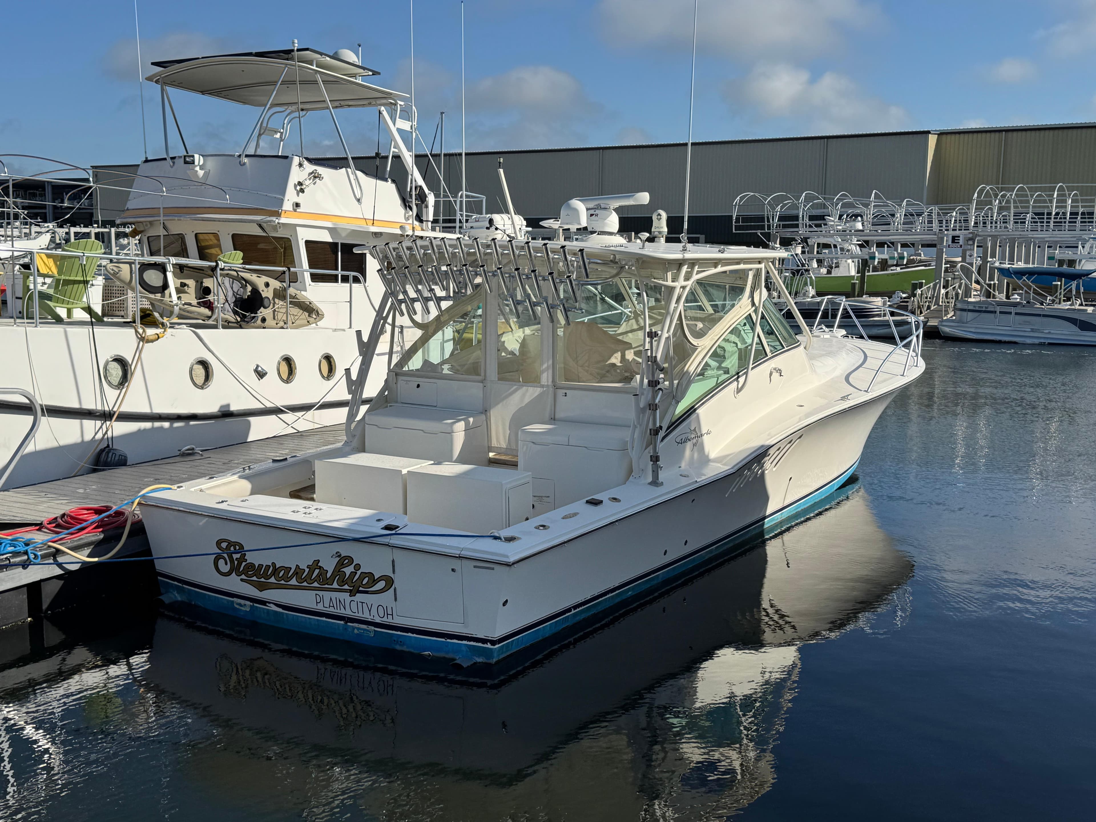 2007 Albemarle 410 Express Fisherman boat docked in a marina, clear sky reflection.