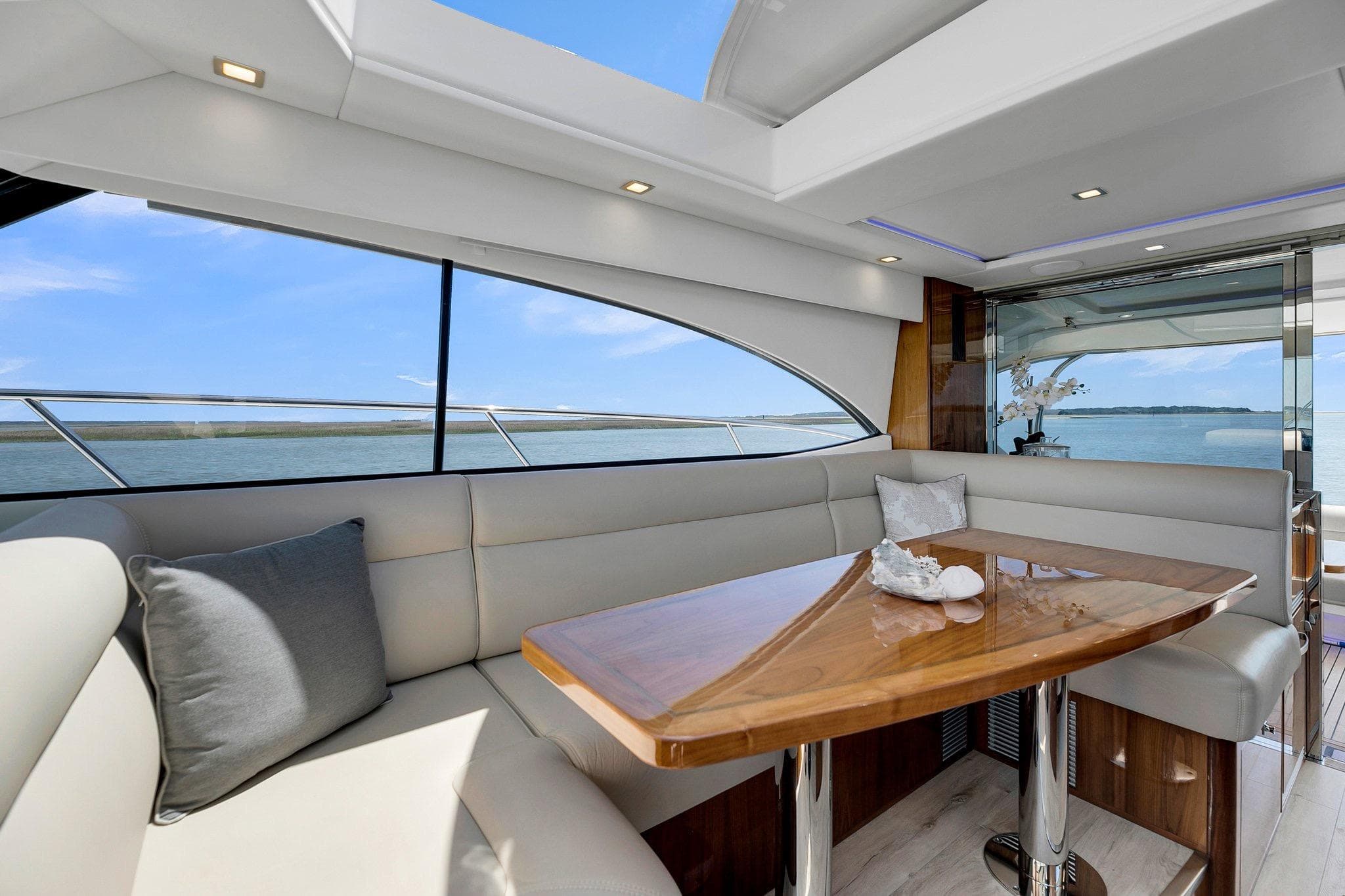 Luxurious interior of 2020 Riviera 4800 Sport Yacht with elegant seating and ocean view.