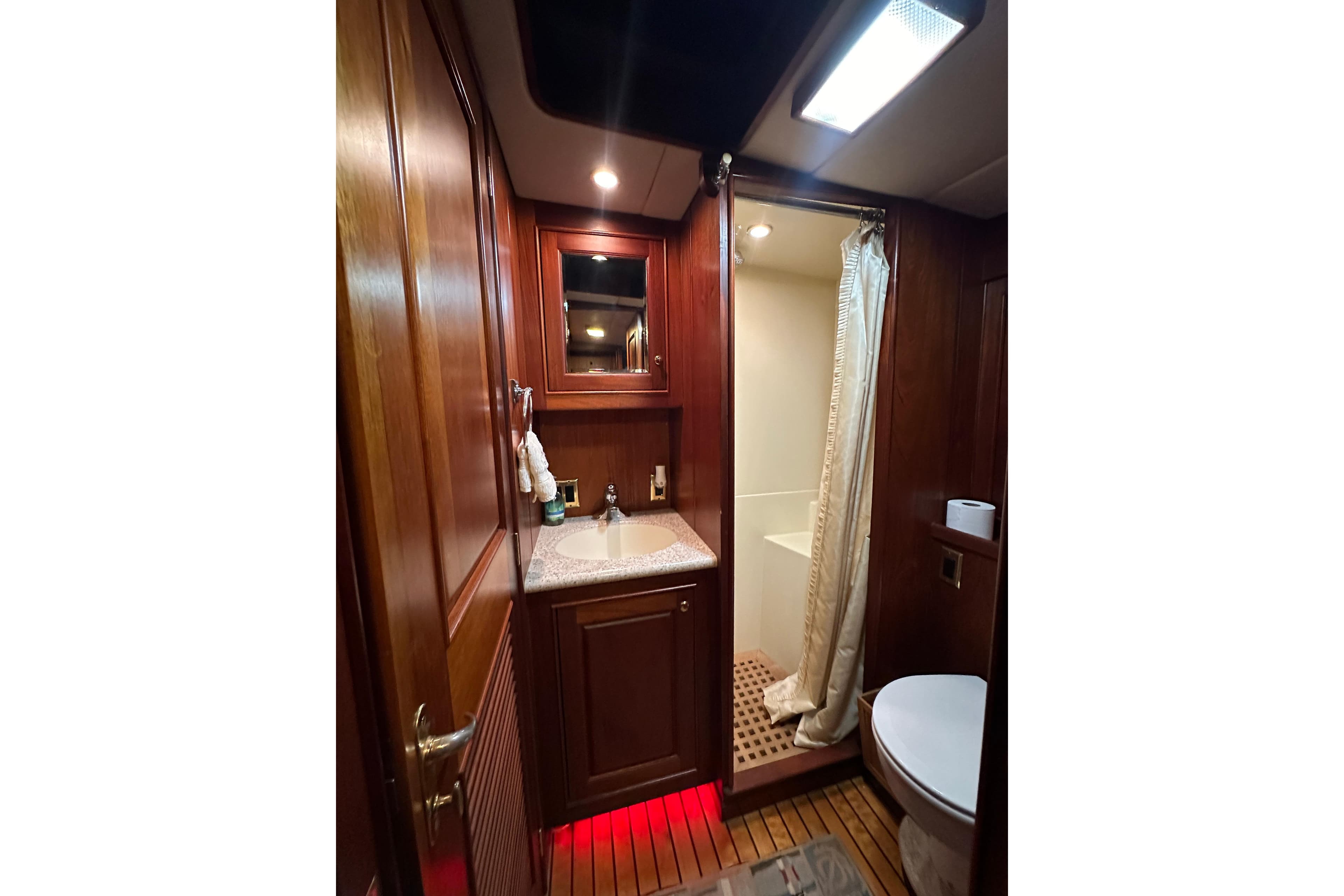 Luxurious bathroom interior of 1980 Bertram 58 Convertible yacht with wood accents.