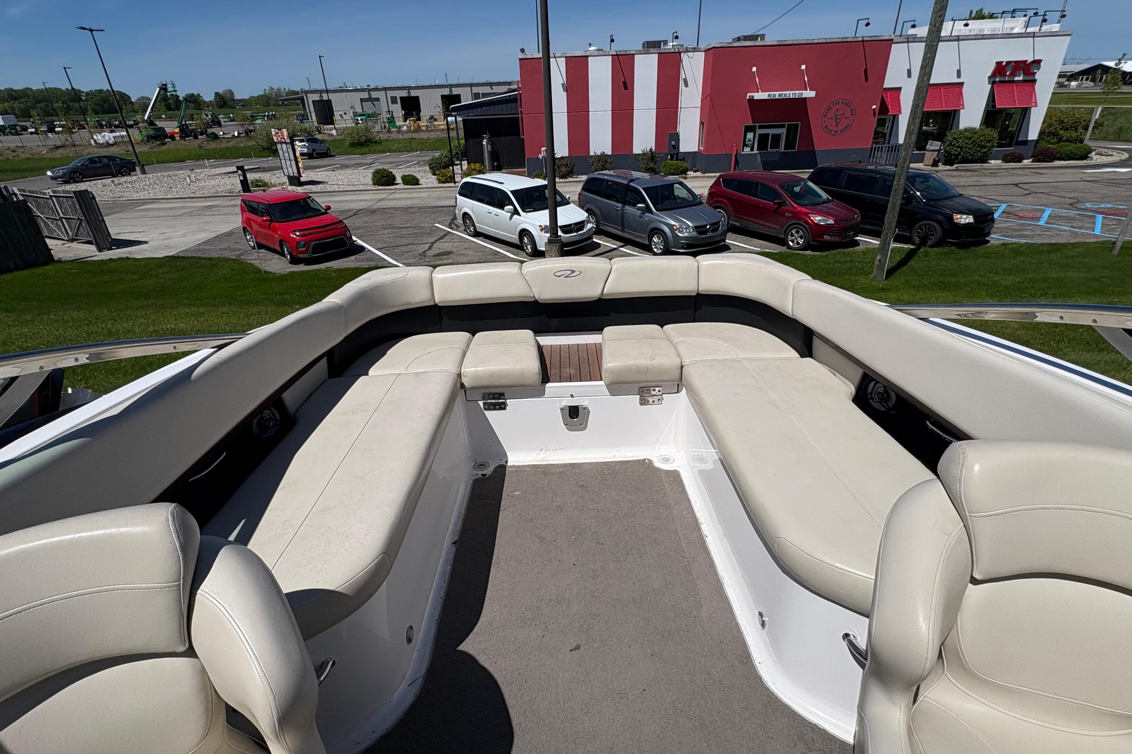 2009 Regal 2500 Bowrider boat interior with beige seating, parked near a restaurant.