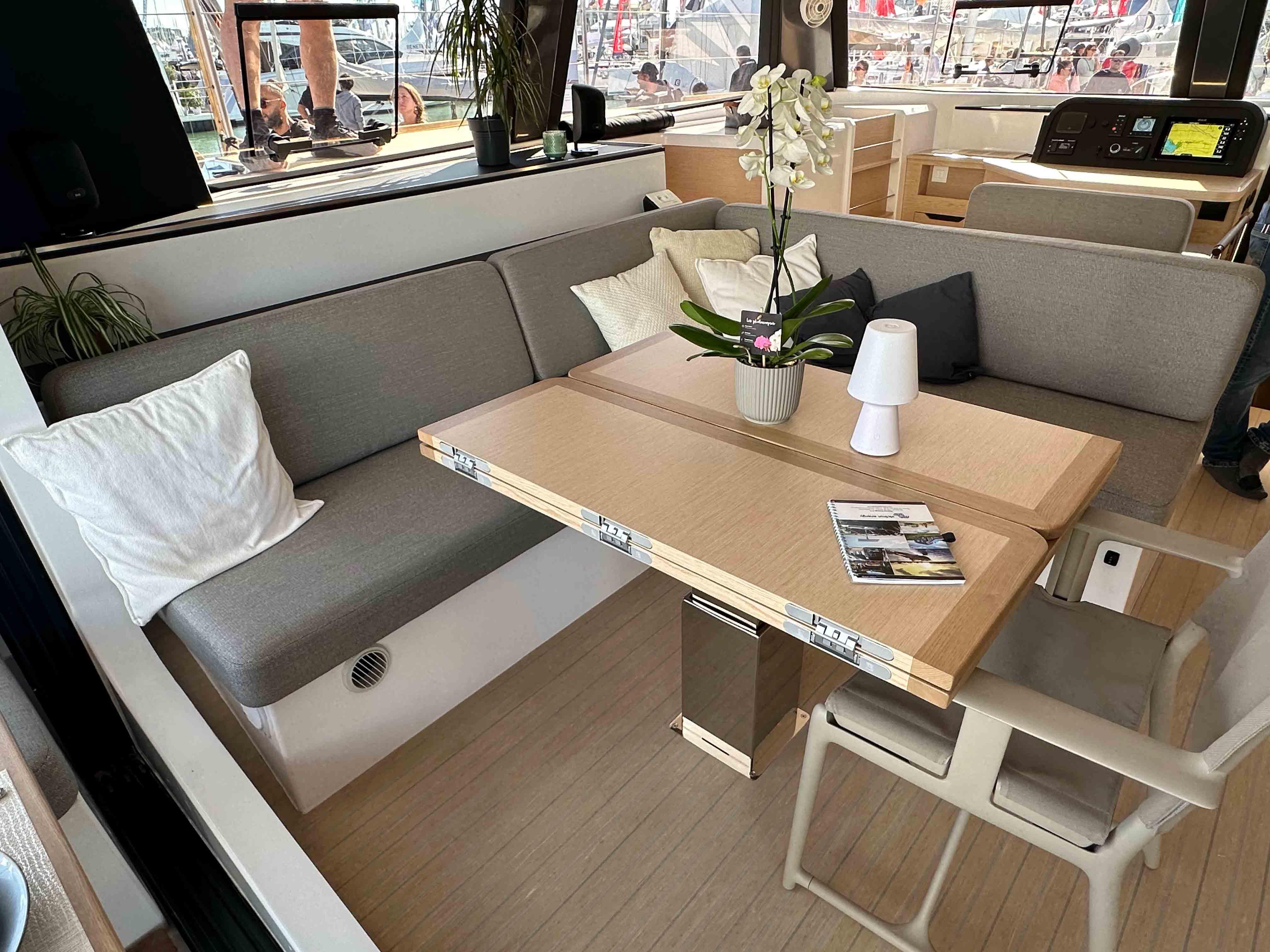 Modern NEEL 52 yacht interior with cozy seating, table, and decor, 2025 model.