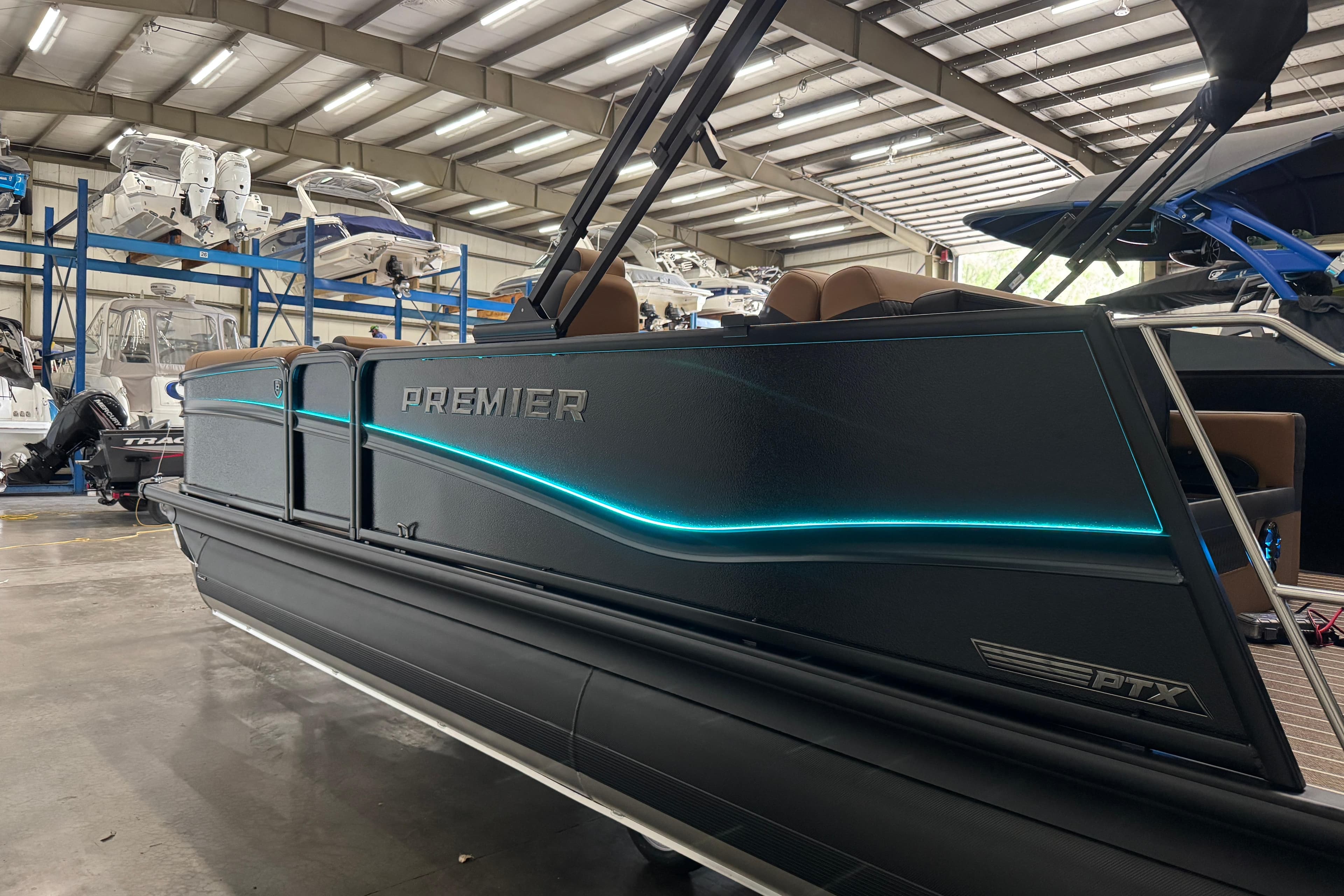 2026 Premier 230 Solaris RL pontoon boat in a showroom with sleek design and blue lighting.
