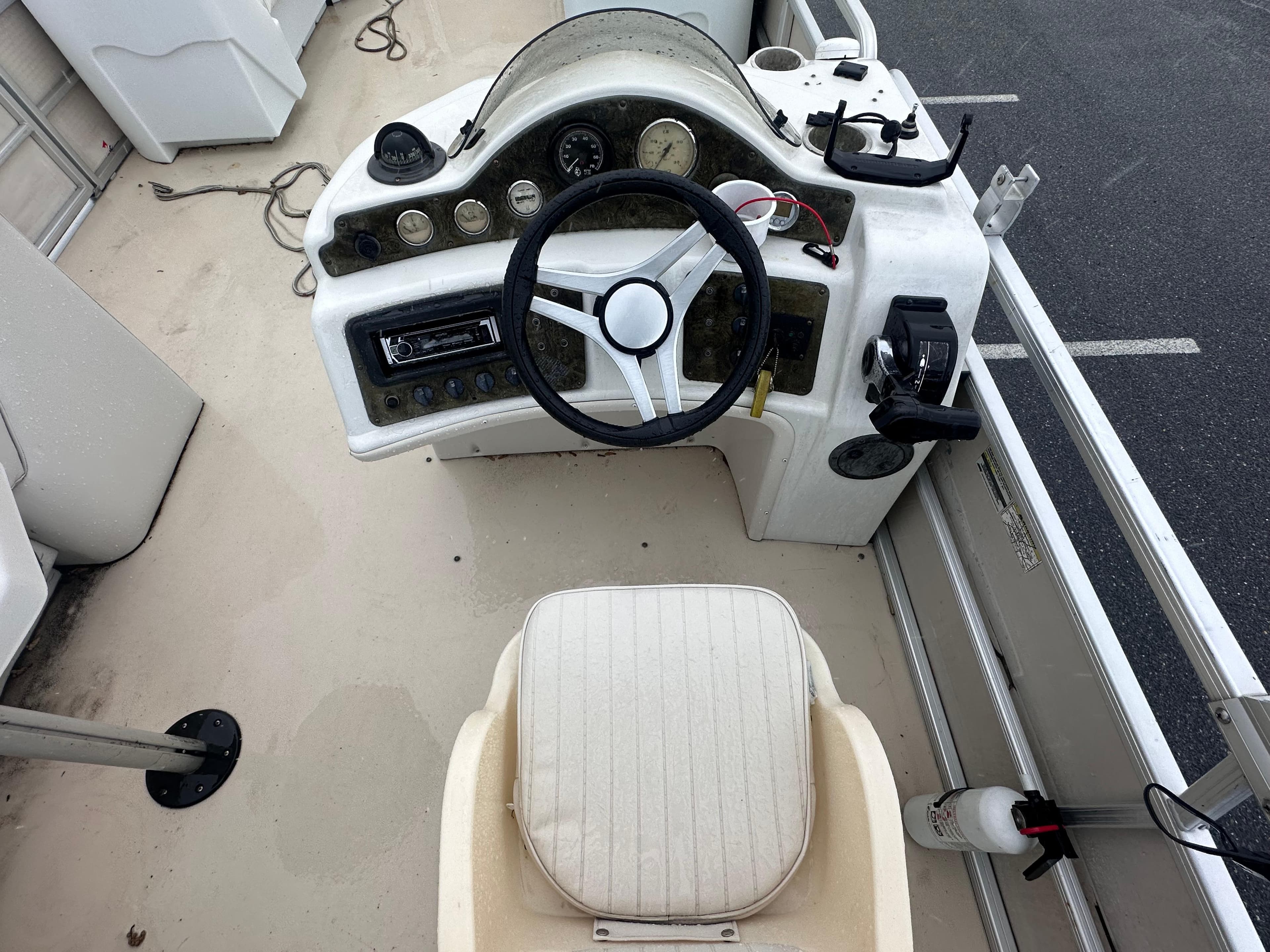 2003 AquaPatio 240 RE boat dashboard with steering wheel and control panel.