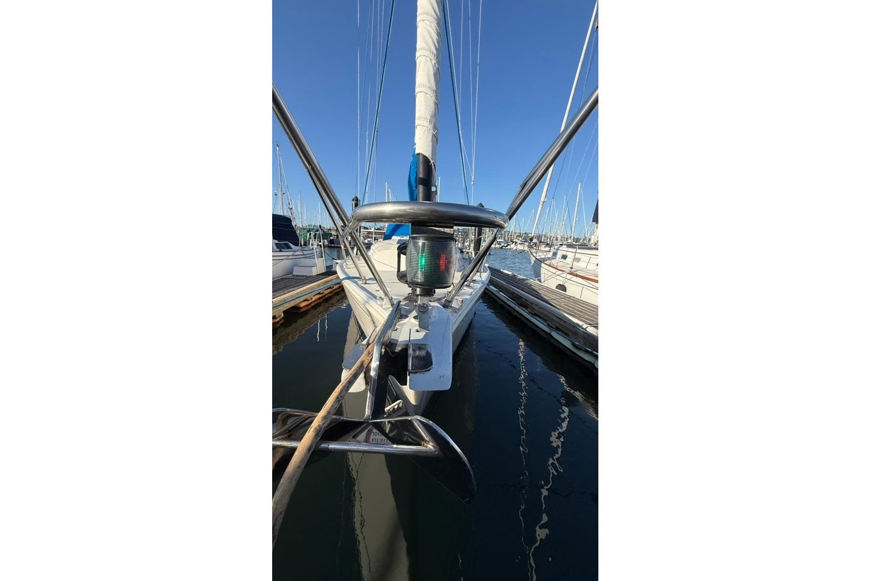1985 Sabre 32 sailboat docked at marina, featuring bow and rigging details.