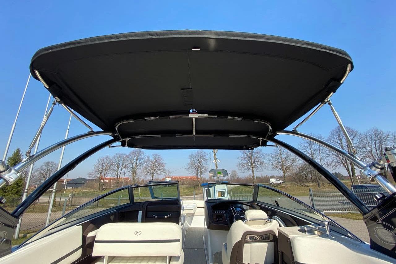 2020 Cobalt R7 Surf boat interior with canopy, showcasing seating and dashboard under clear blue sky.