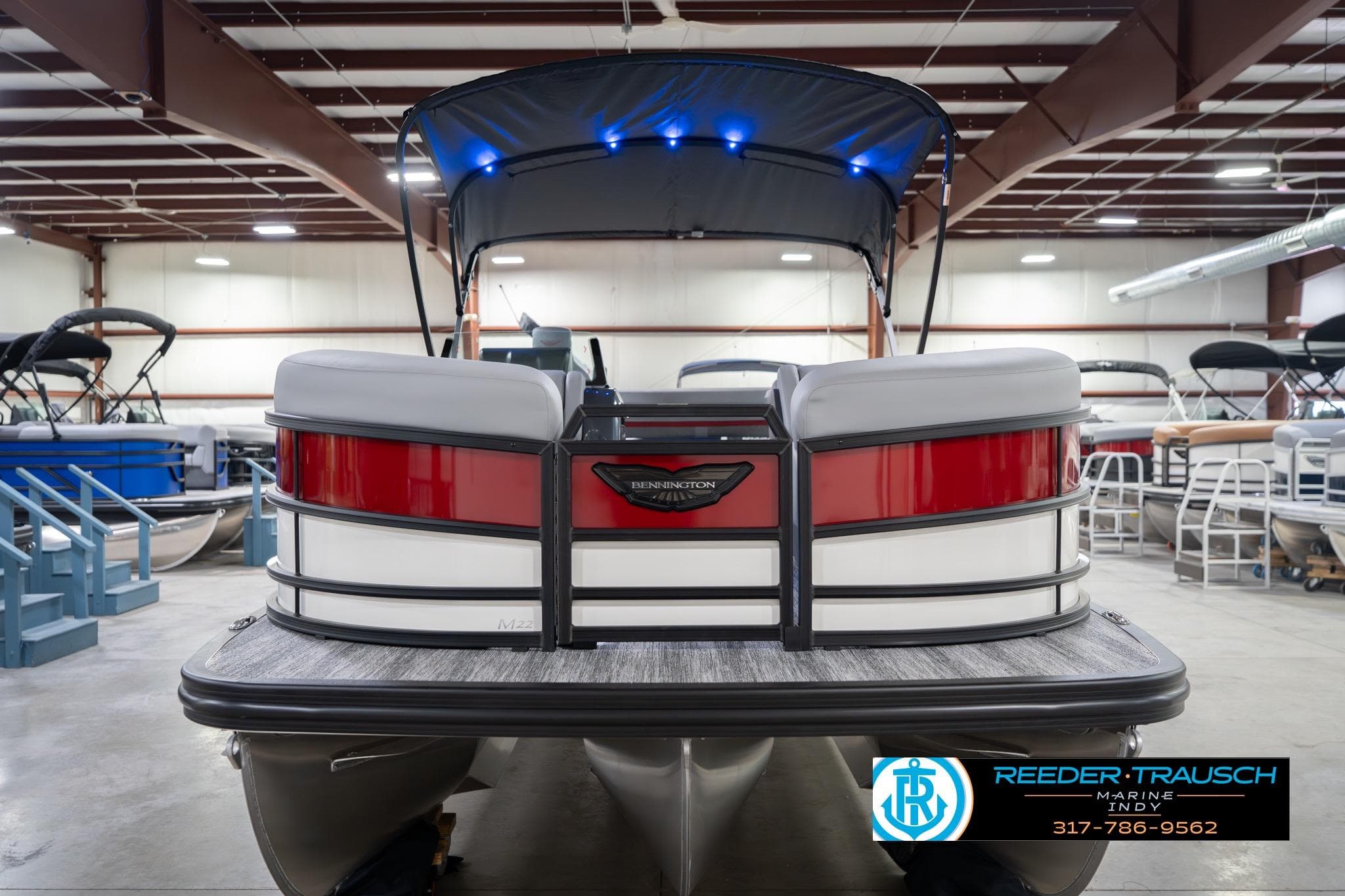 2026 Bennington 22 ML pontoon boat in showroom with canopy and modern design.