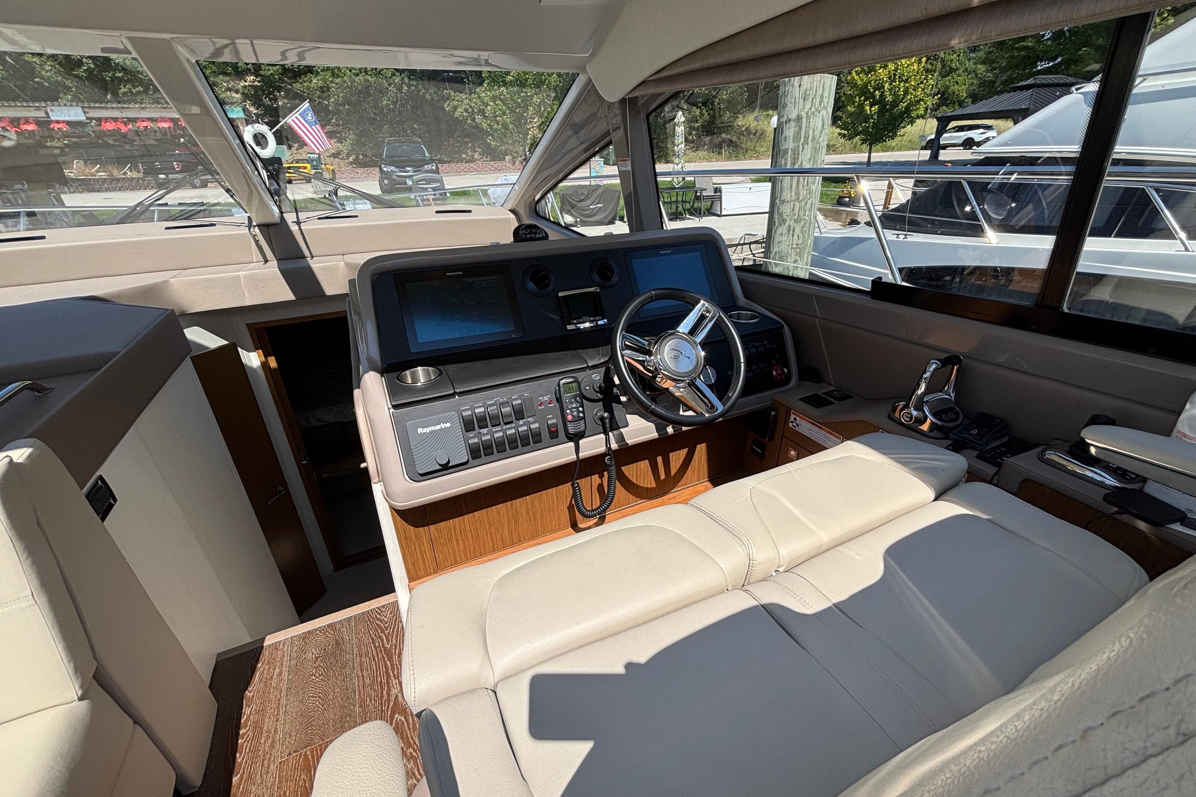 Interior of 2018 Sea Ray Sundancer 460 yacht, featuring helm with modern controls and leather seating.