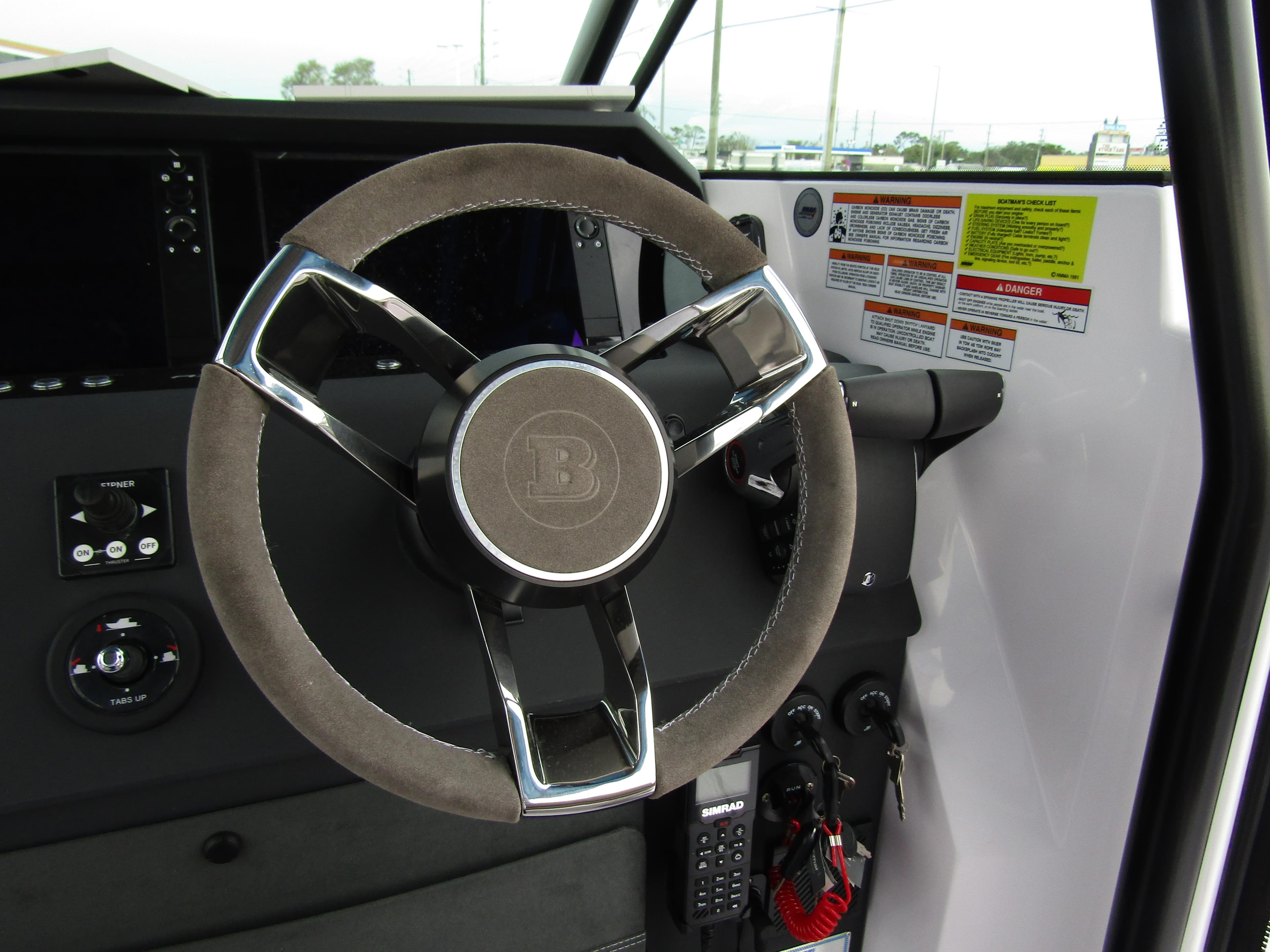 Steering wheel of 2024 Axopar 37 Sun Top boat, featuring modern controls and dashboard.