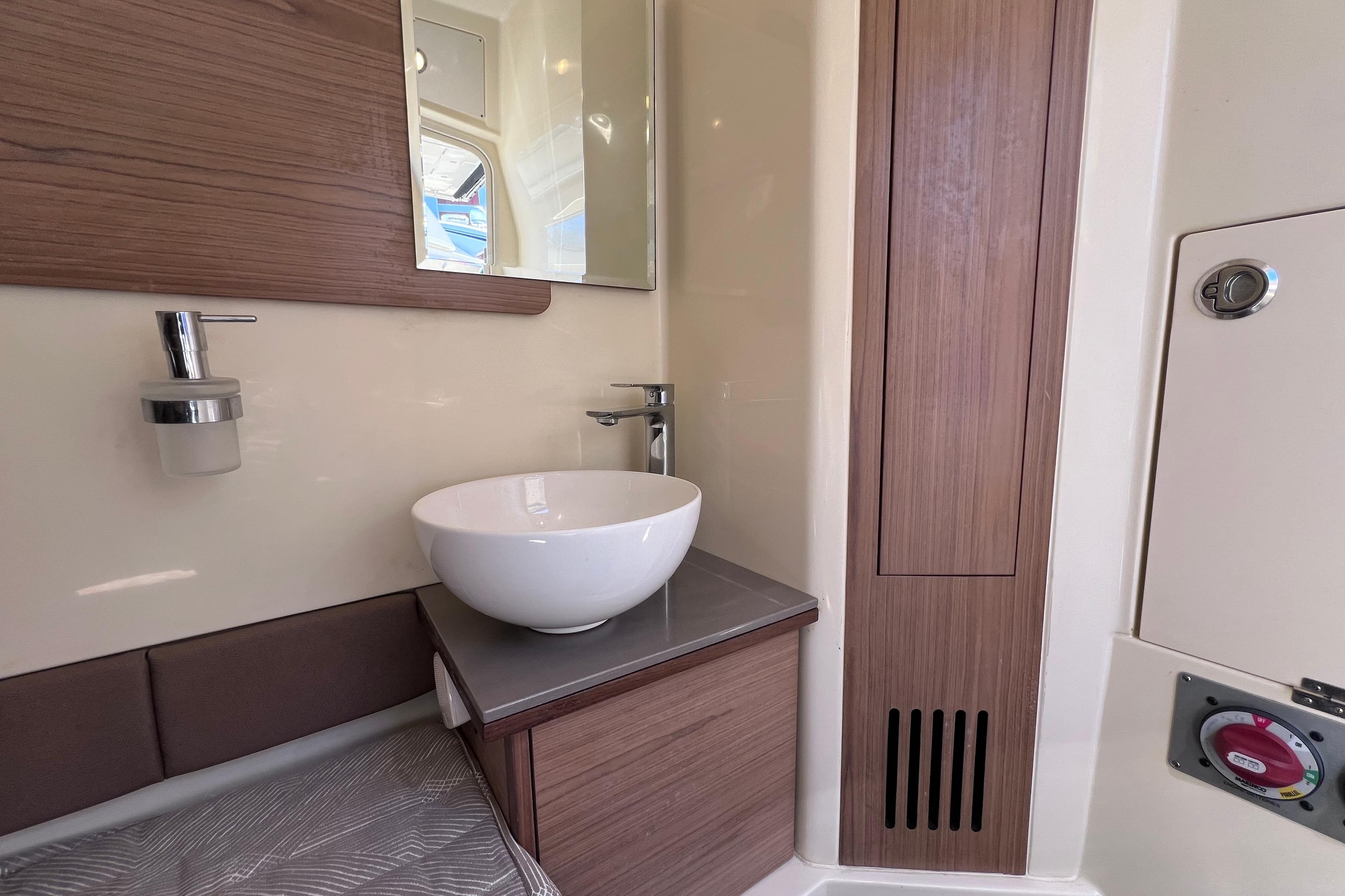2022 Chris-Craft Catalina 30 bathroom with modern sink and wooden accents.