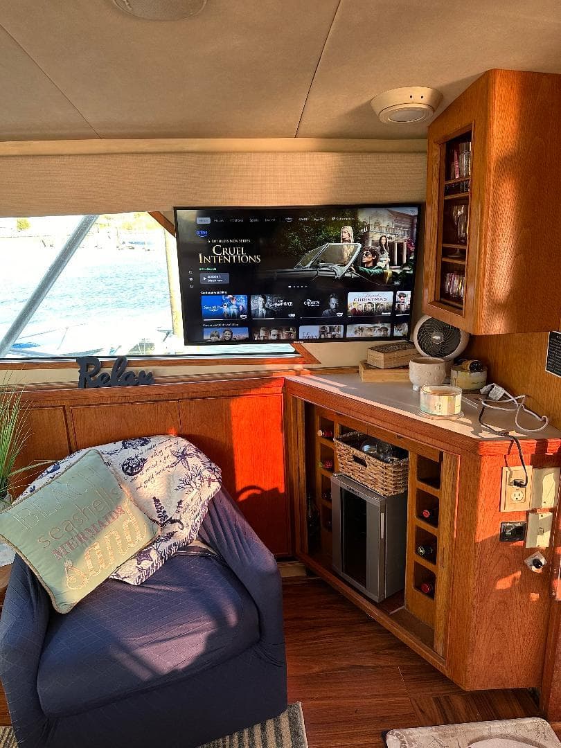 Interior of a 1989 Bertram 43 Convertible yacht with cozy seating and entertainment setup.