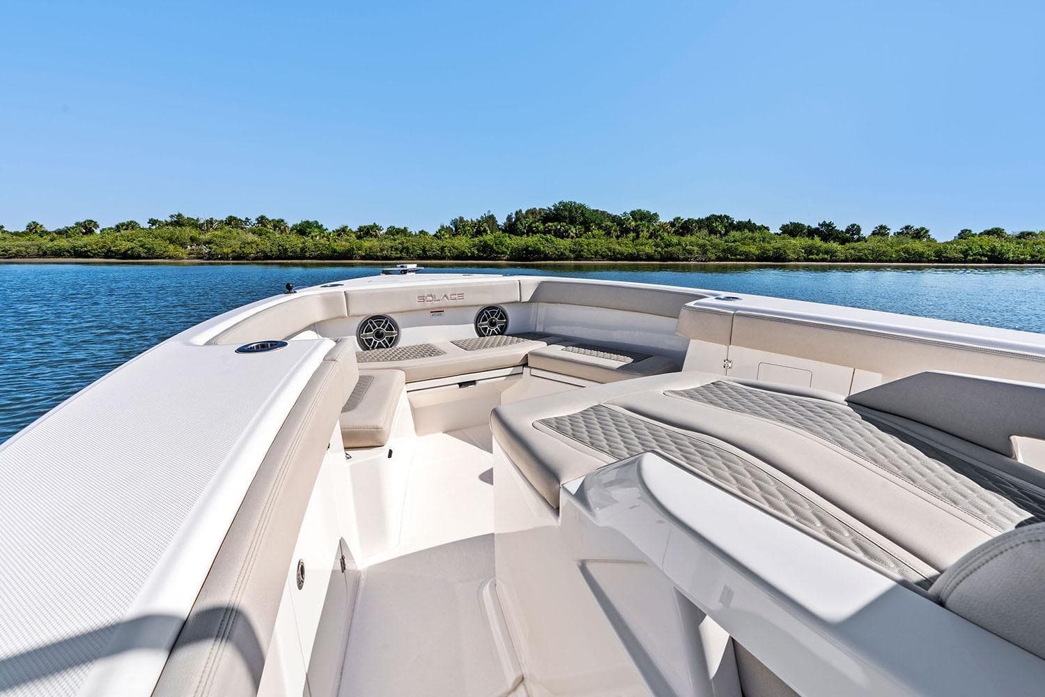 Manufacturer Provided Image: Luxurious 2026 Solace 32 CS boat interior with plush seating on a serene waterway.