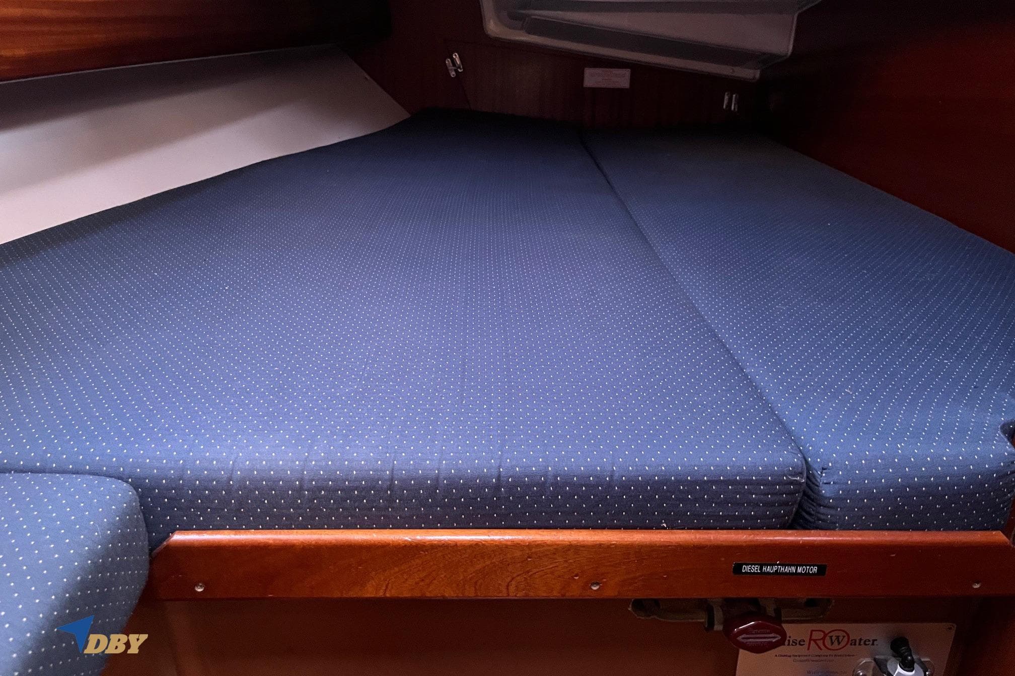 Cozy cabin bed in 2004 Bavaria 44 yacht with blue polka dot mattress.
