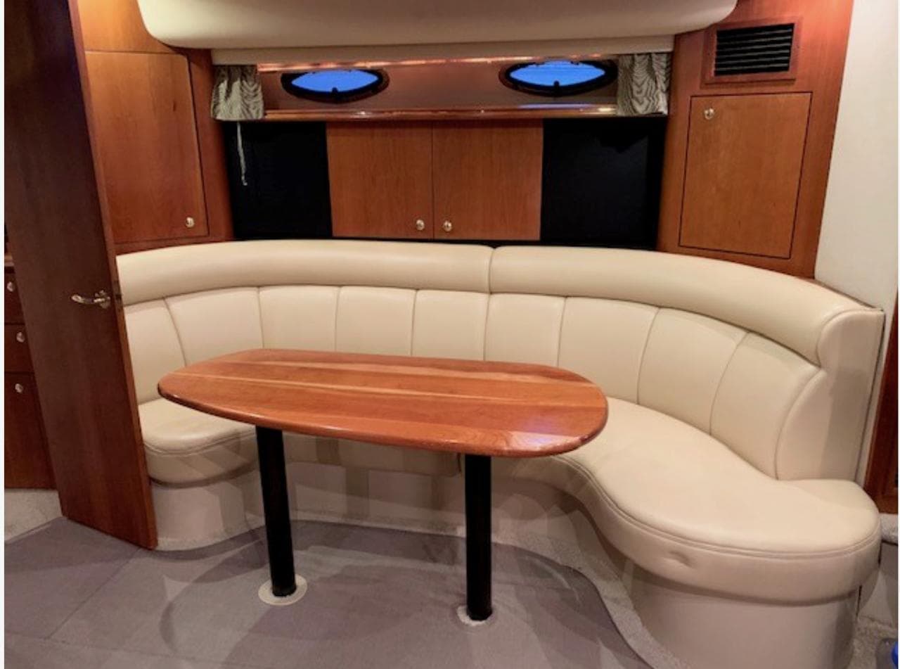 2002 Cruisers Yachts 3870 Express interior with leather sofa and wooden table.
