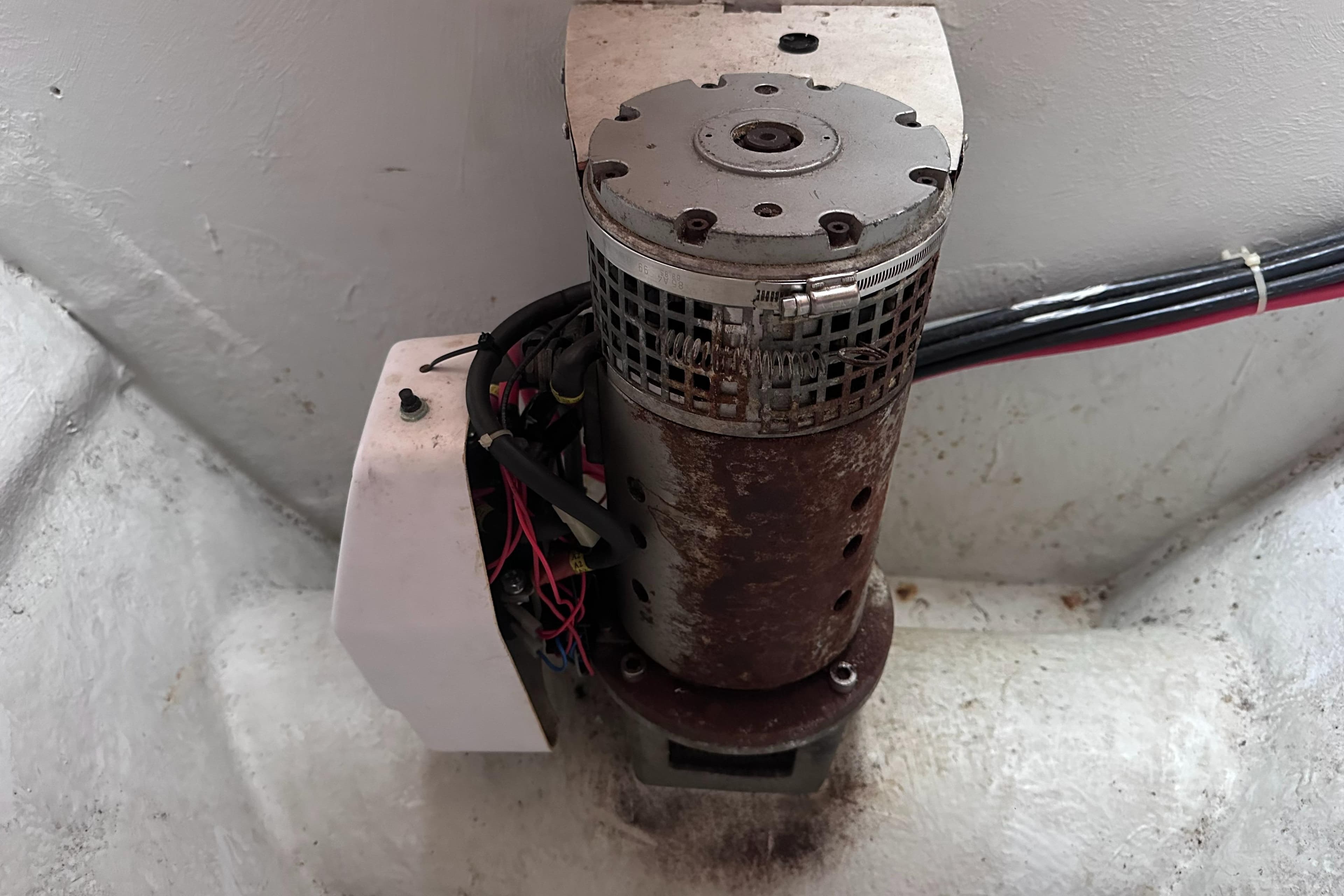 Rusty motor component in a 2000 Hallberg-Rassy 46 yacht, showing wiring and metal casing.