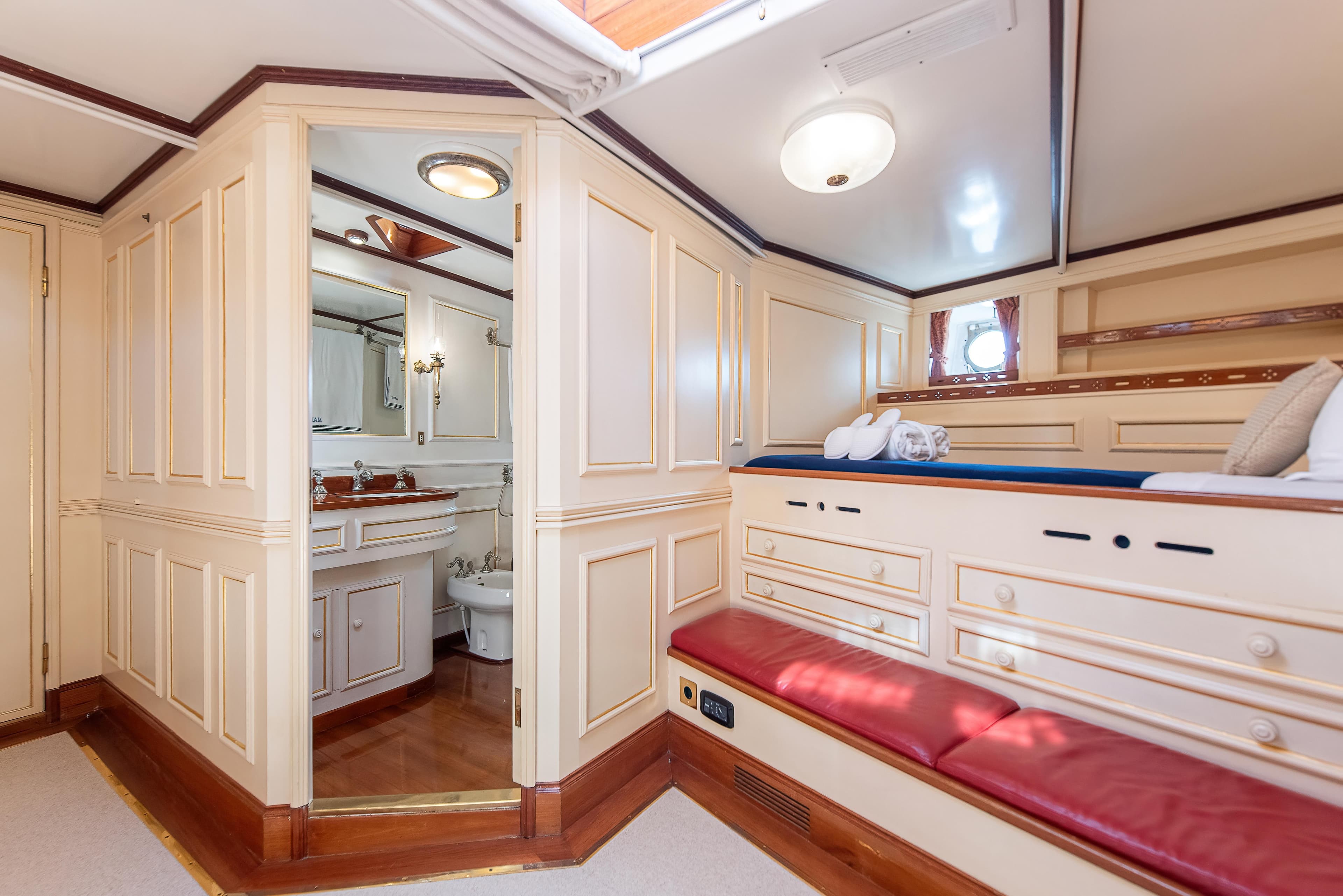 Luxurious interior of 1915 Herreshoff Performance Schooner with elegant woodwork and cozy seating.
