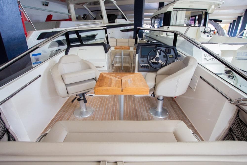 Interior of a 2016 Draco 27RS boat with seating and steering console.