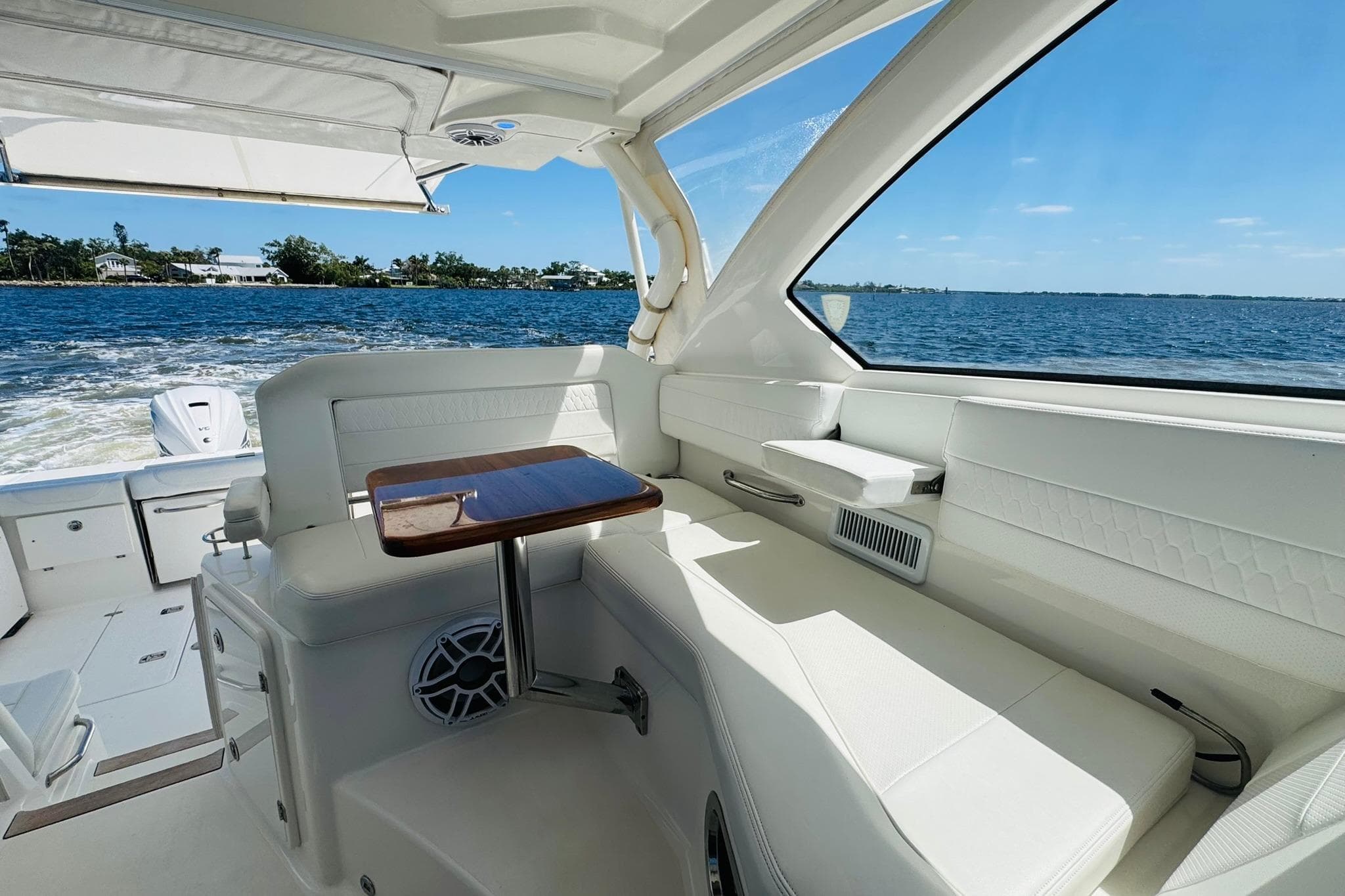 Interior of 2021 Pursuit OS 355 Offshore boat with white seating and ocean view.