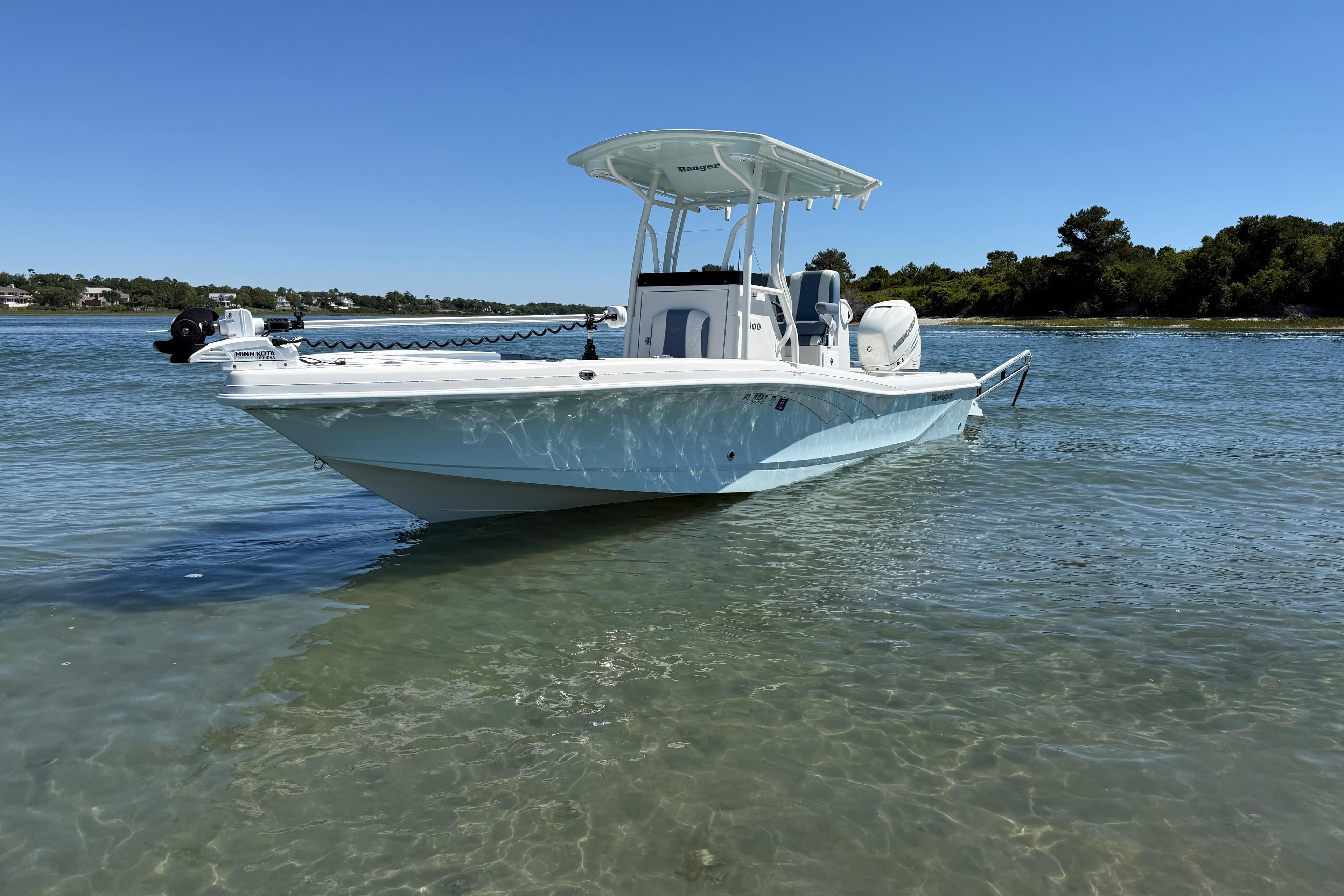 2022 Ranger 2600 Bay boat anchored in clear, shallow water under a bright blue sky.