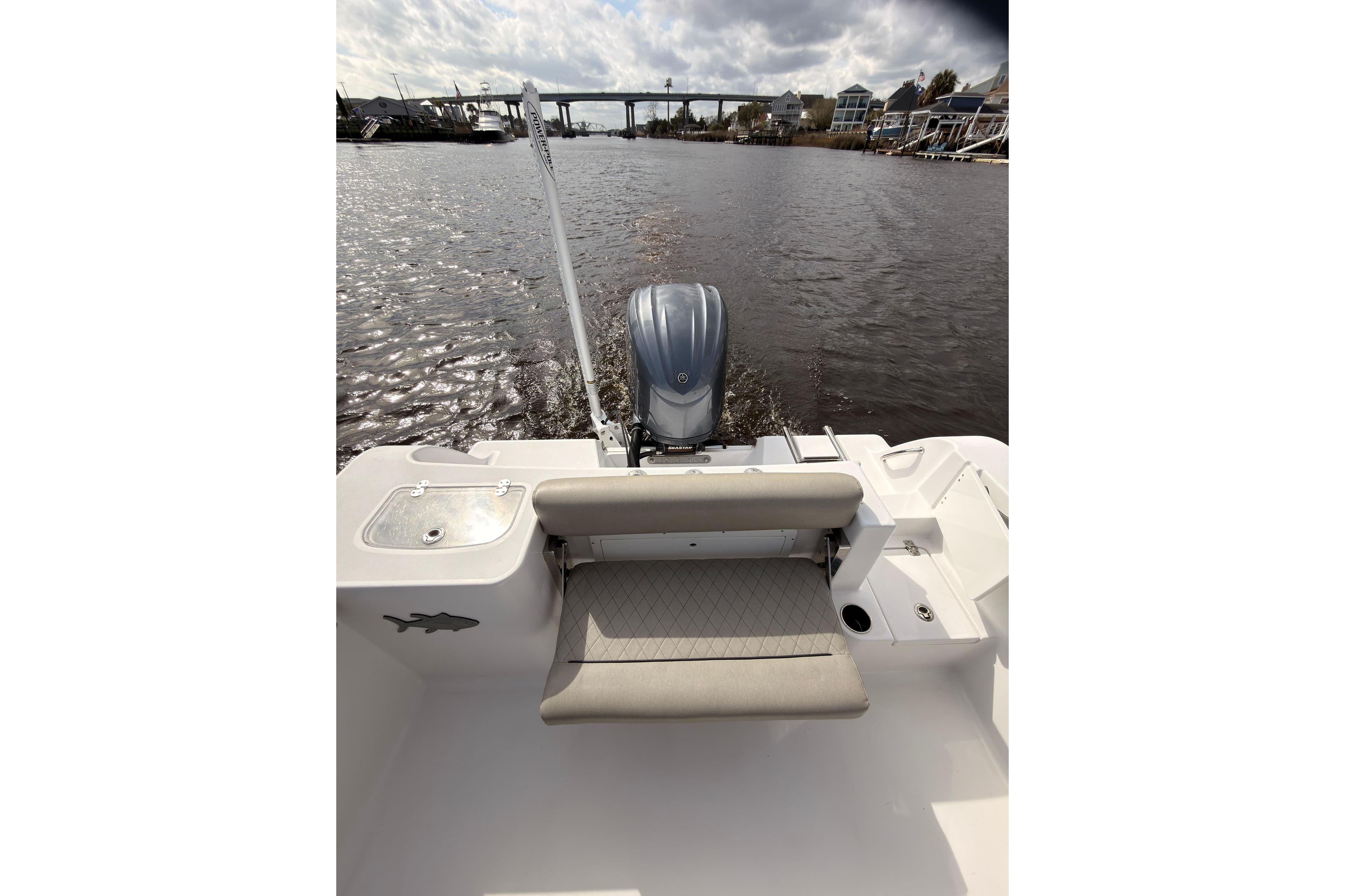 2022 Sportsman Open 242 Center Console boat on a calm river with bridge view.