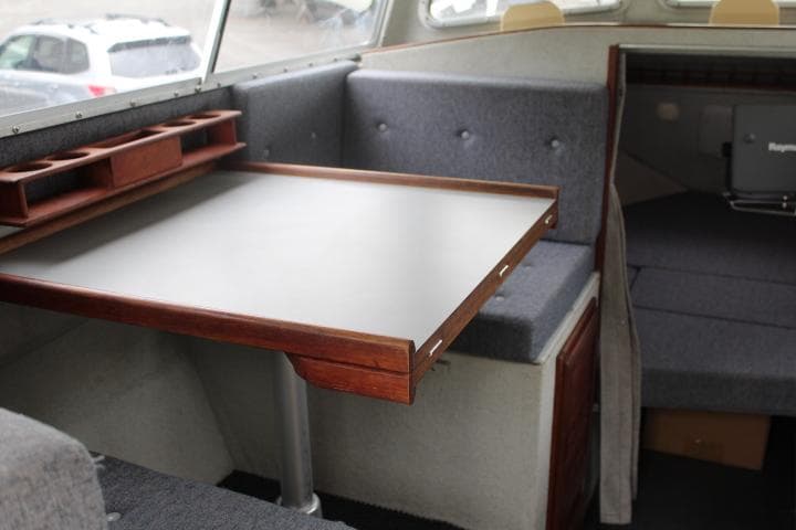 Interior of a 1995 SeaSport 2400 Explorer boat with a foldable table and seating area.