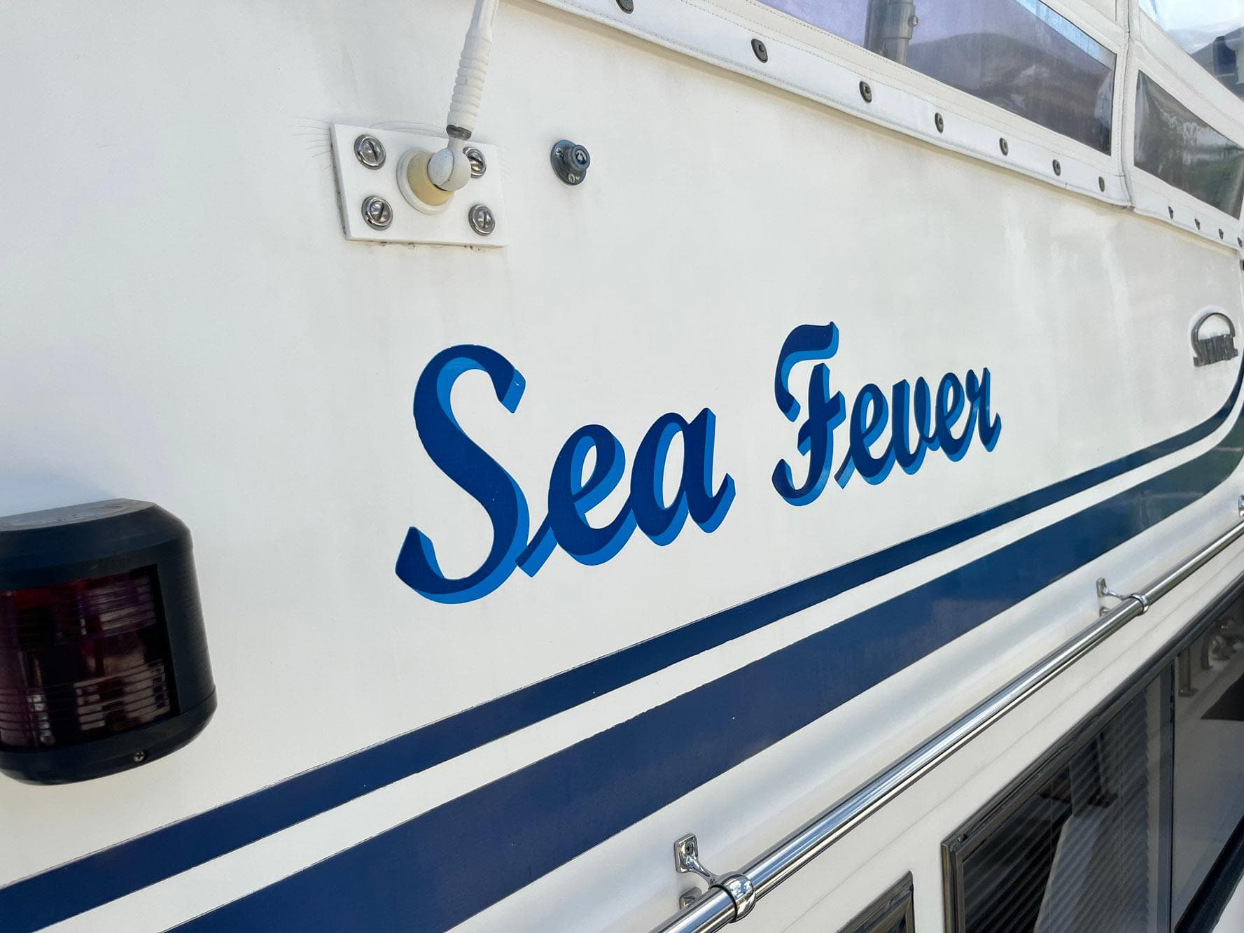 1987 Symbol 44 Sun Deck MK II boat with "Sea Fever" name in blue lettering.
