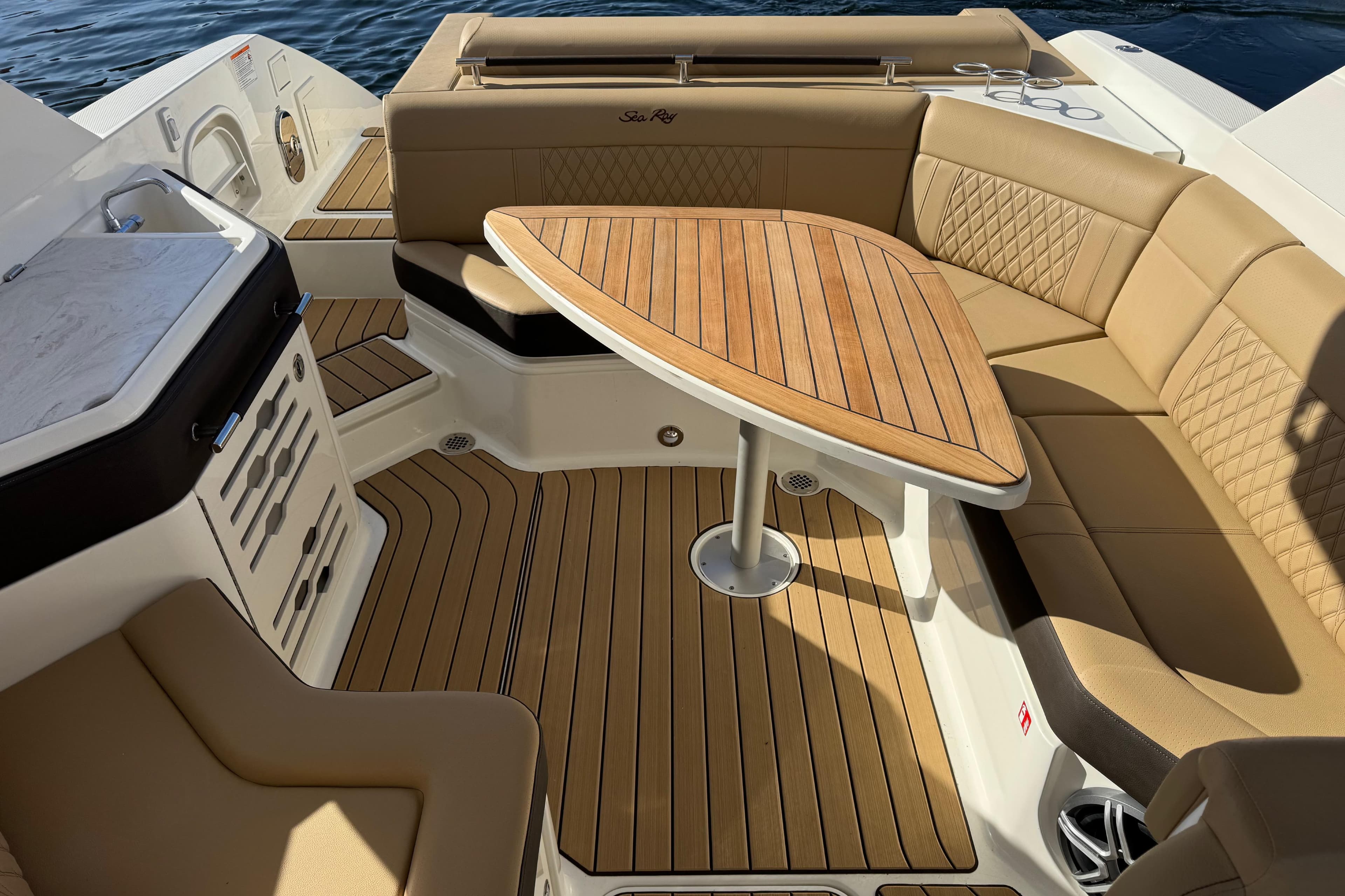Luxurious 2026 Sea Ray SLX 310 boat interior with elegant seating and wooden table.