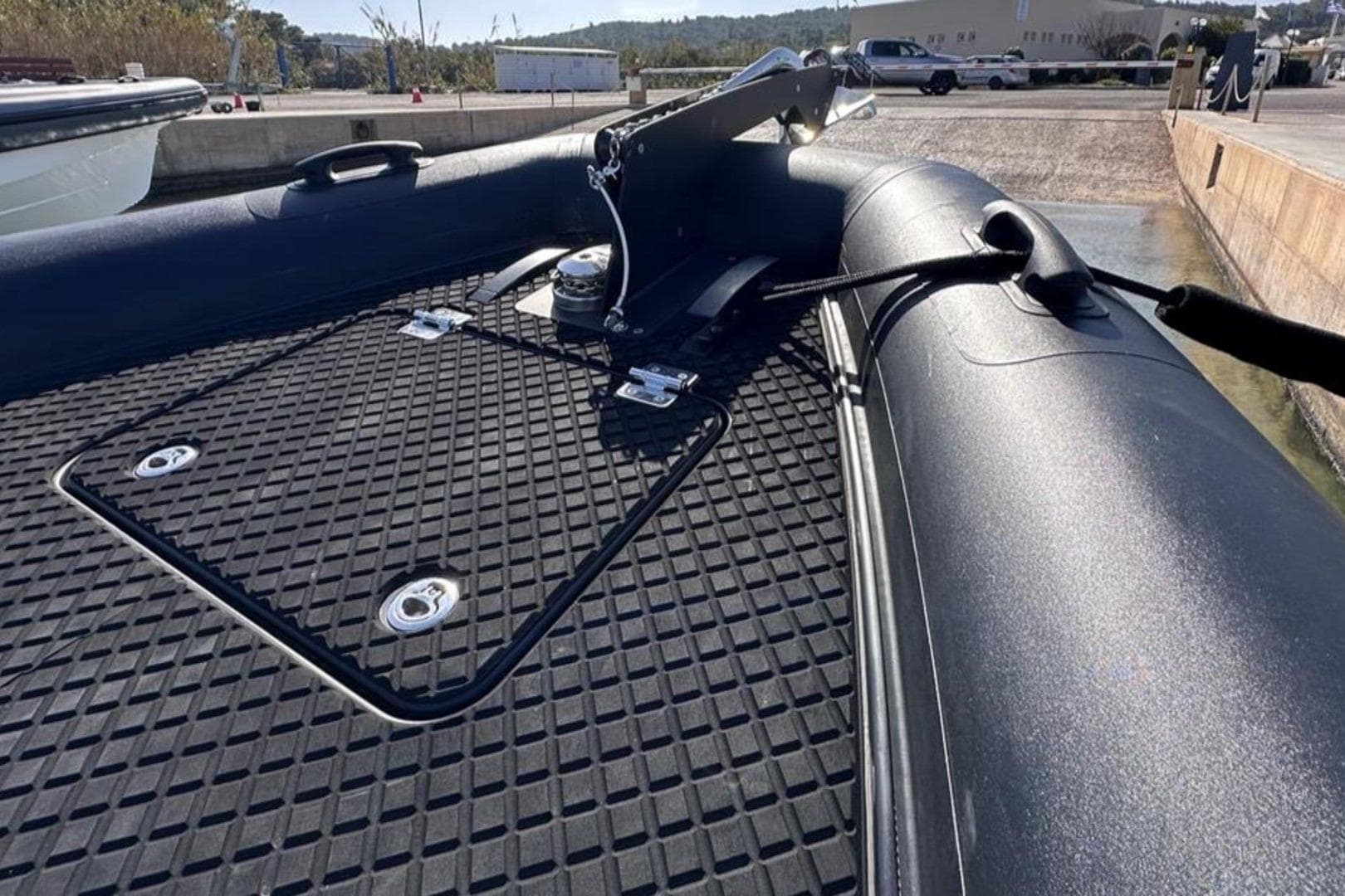 2023 Goldfish X10 EXPLORER boat deck with textured surface and hatch, docked at marina.