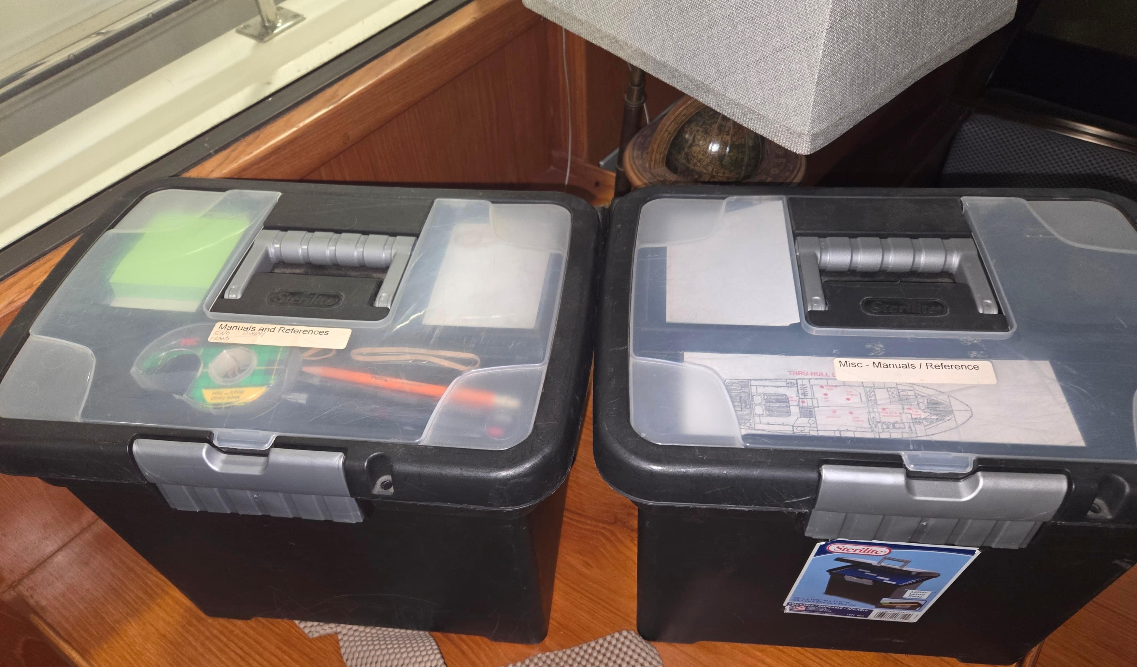 Storage boxes on a 1989 Marine Trader 47 CMY boat, containing tools and manuals.
