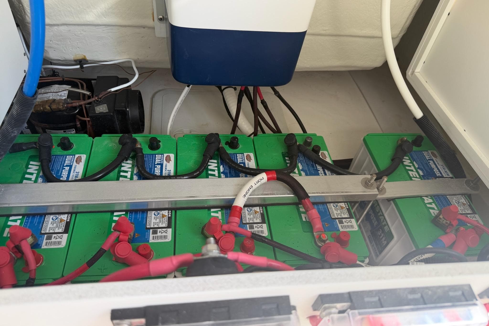 Battery compartment of 2024 Everglades 335 Center Console boat, featuring multiple green batteries.