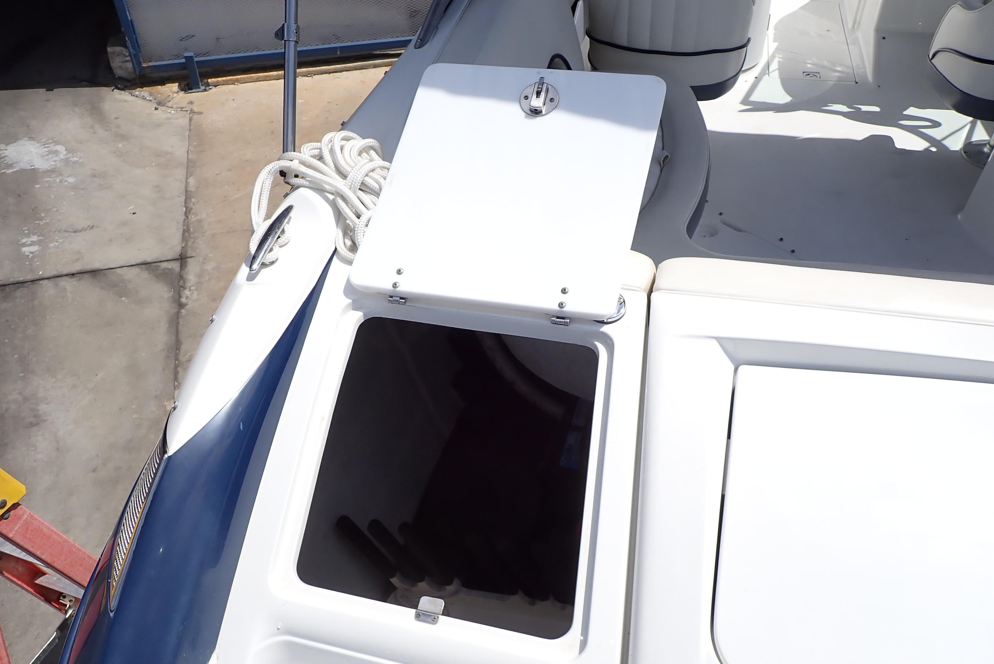 Open storage compartment on a 2002 Cobalt 240 boat deck.