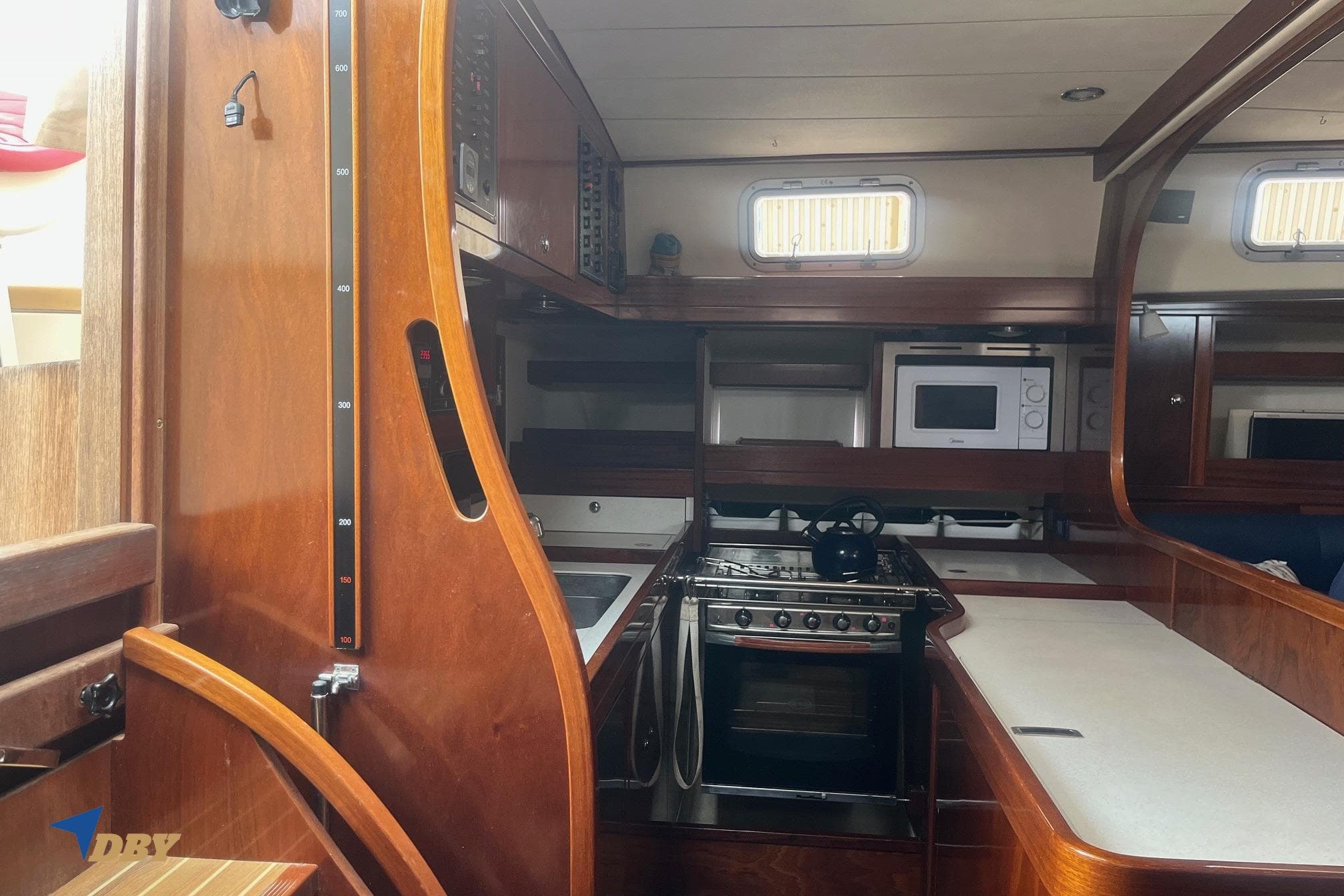 Interior of 2006 Amel 54 yacht kitchen with wooden cabinetry and modern appliances.