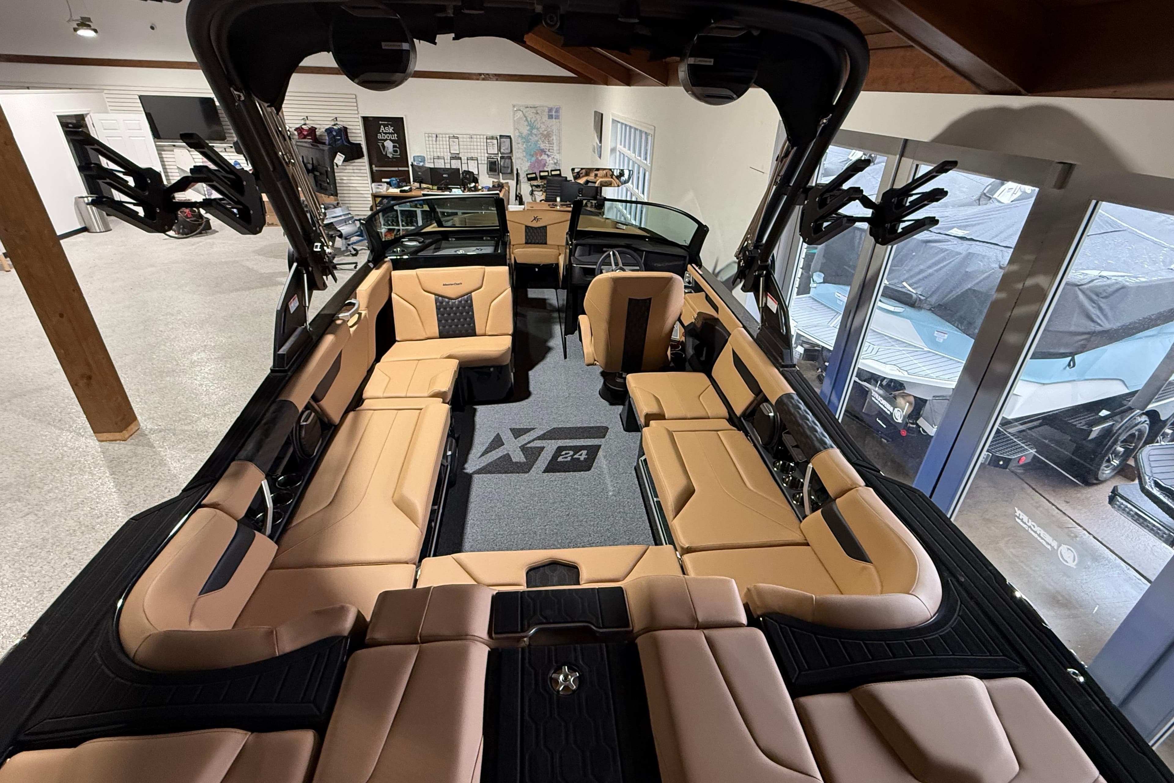 2026 MasterCraft XT24 boat interior with tan seating and modern design in showroom.