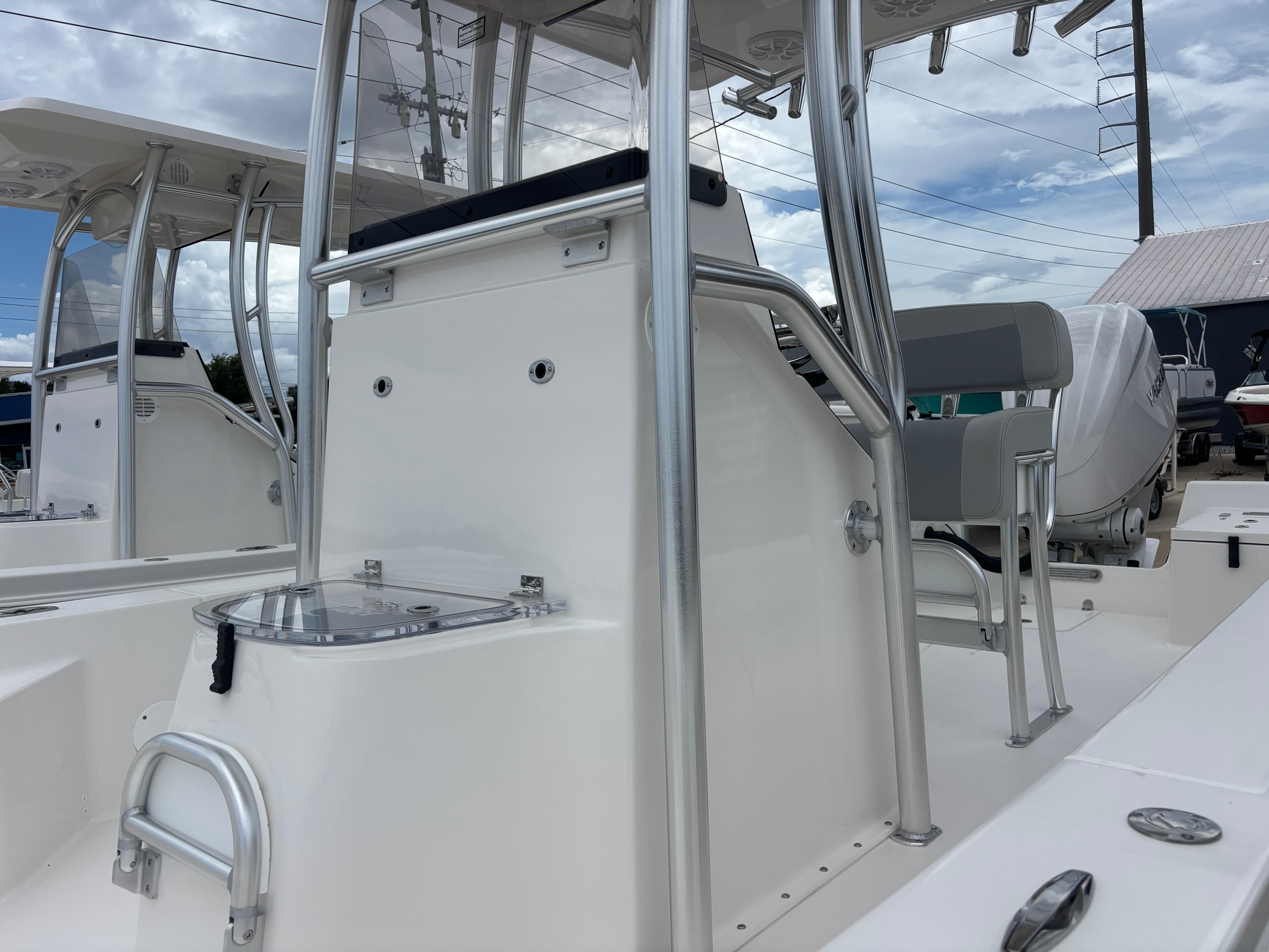 2026 Bay Rider 239 Bay boat interior with seating and console, under a cloudy sky.