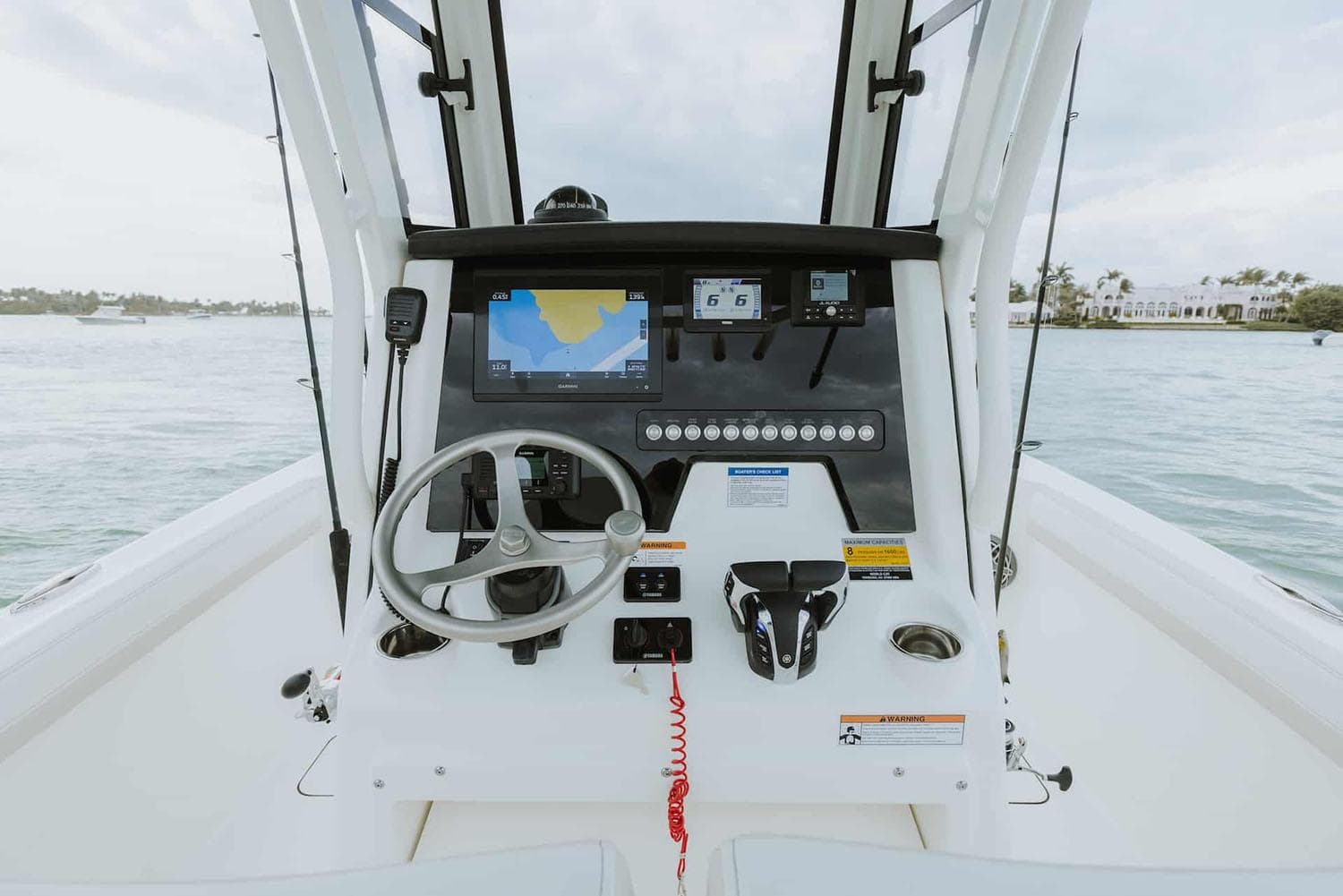 Manufacturer Provided Image: 2026 World Cat 235 TE boat dashboard with steering wheel and navigation system on open water.