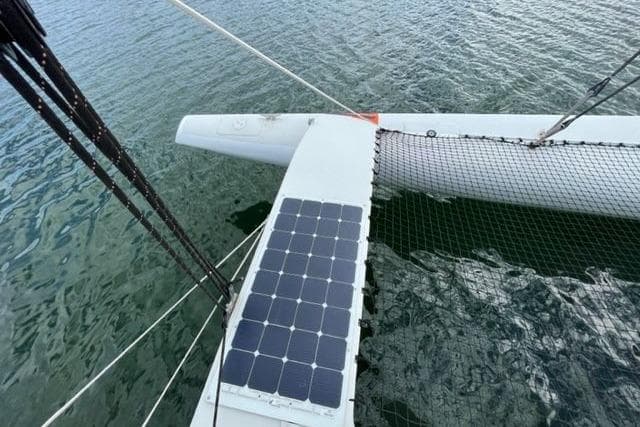 Custom 2009 Trimaran with solar panel on deck, floating on calm water.