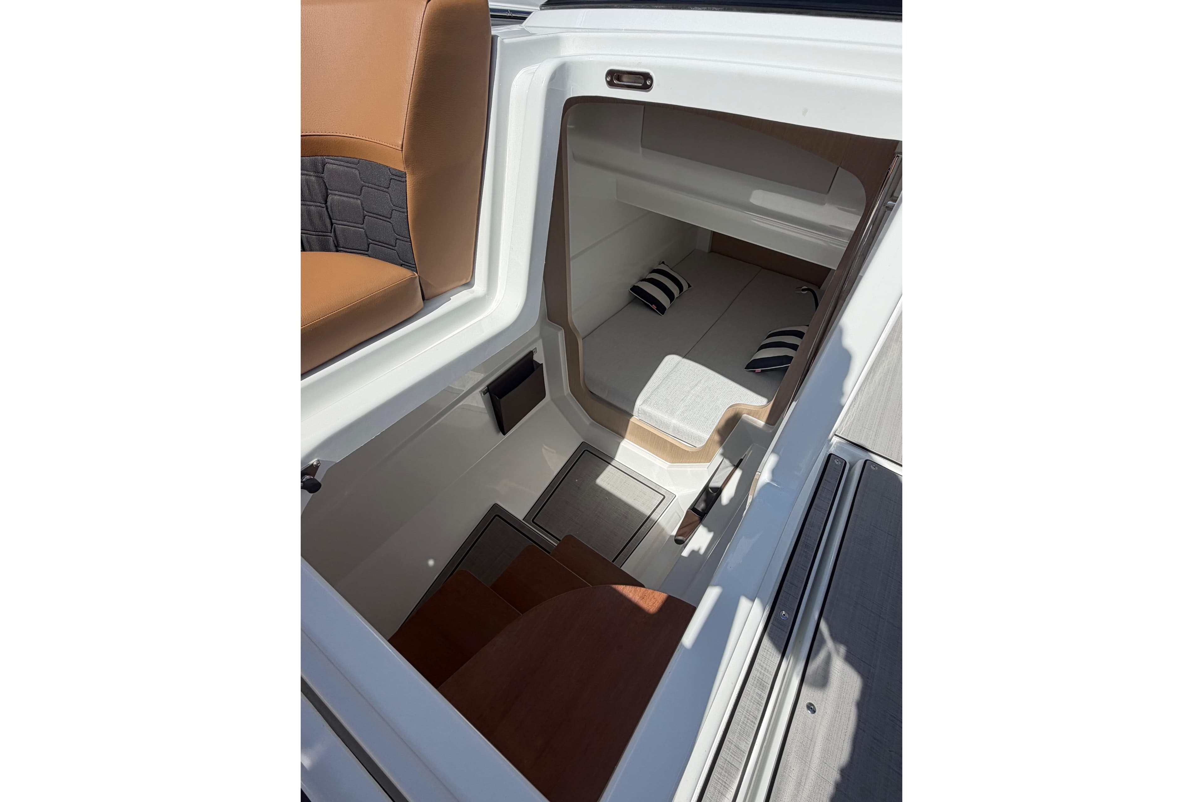 Interior view of 2026 Jeanneau TH33 boat cabin with seating and cushions.
