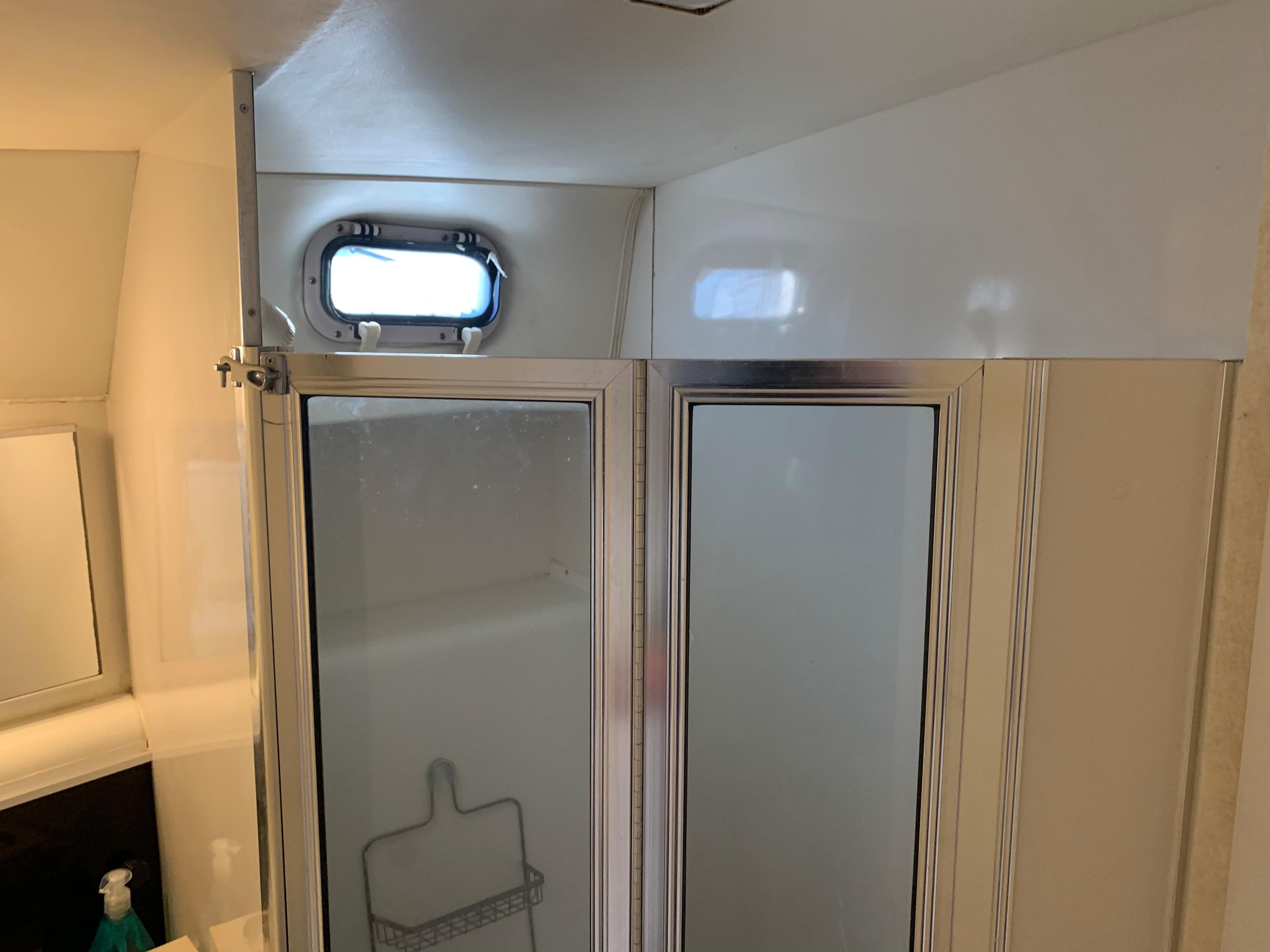 Shower area inside a 1992 Silverton 34 Aft Cabin Motor Yacht, featuring a small window.