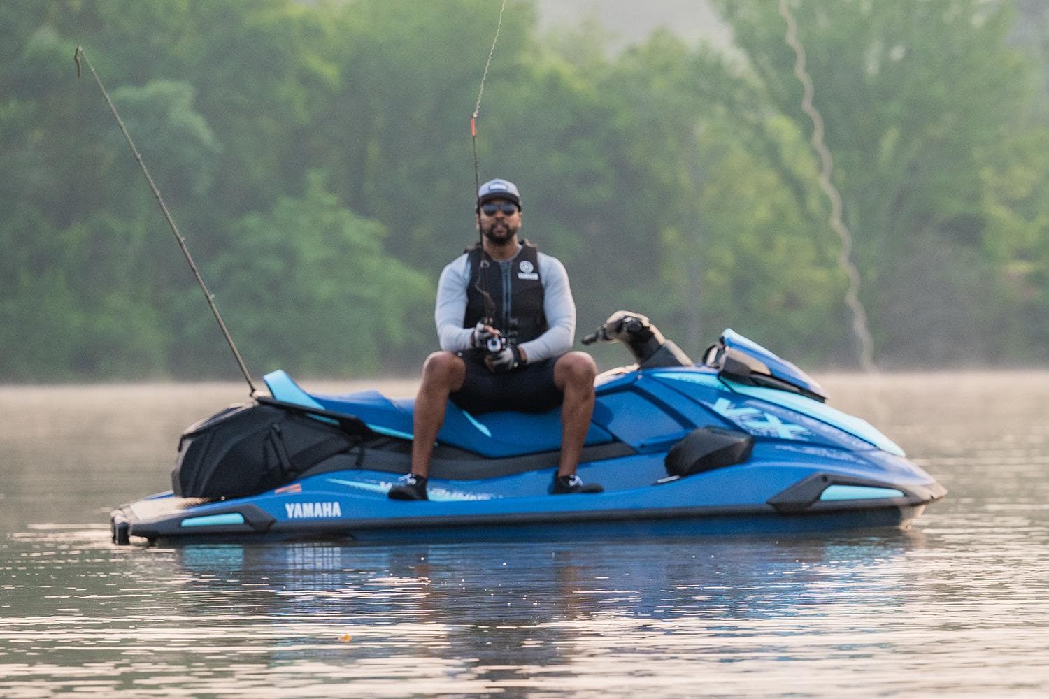 Manufacturer Provided Image: Man fishing on a 2026 Yamaha WaveRunner VX Cruiser in a serene lake setting.