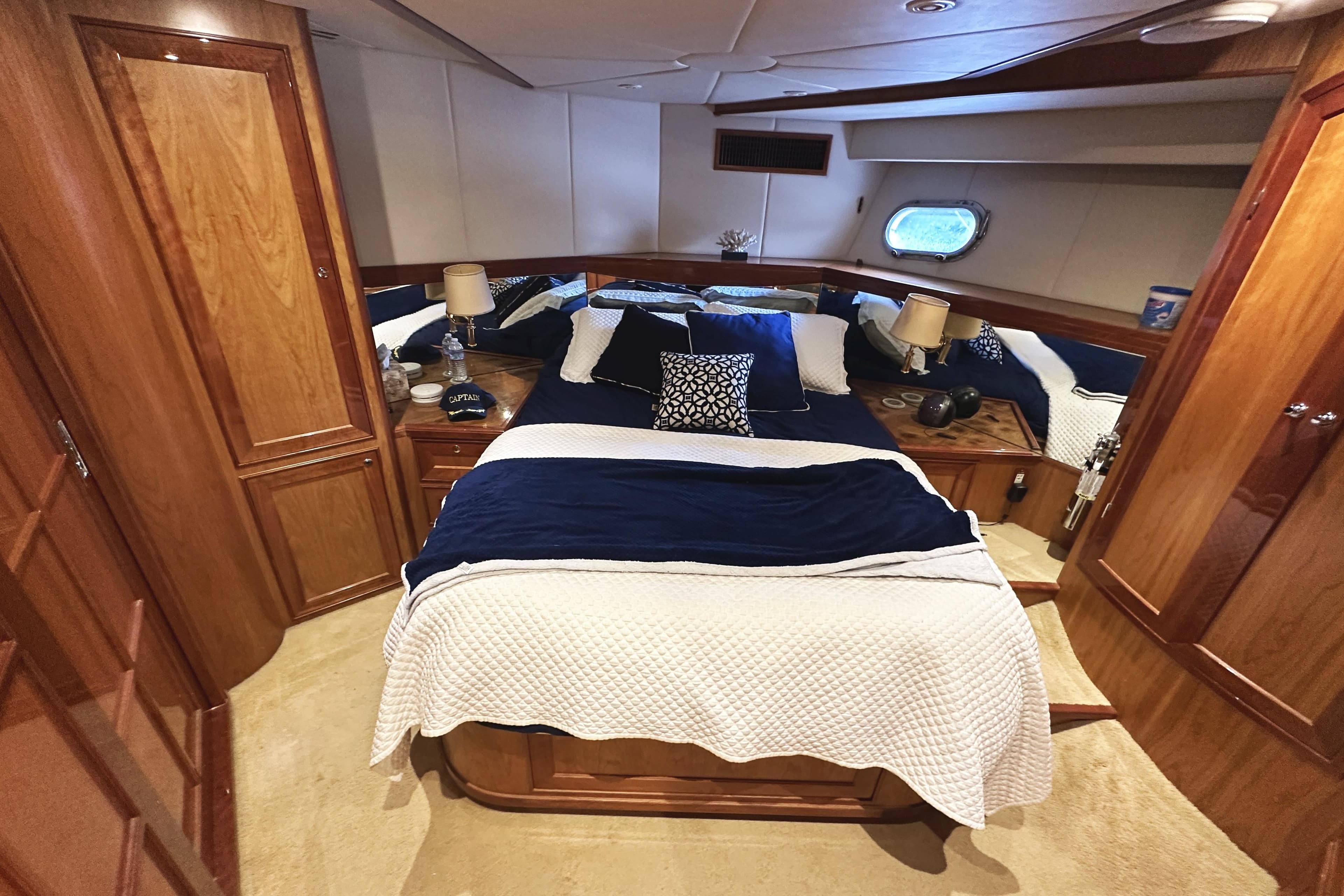 Luxurious cabin interior of 2004 McKinna 57 PHMY yacht with elegant bedding and wood finishes.