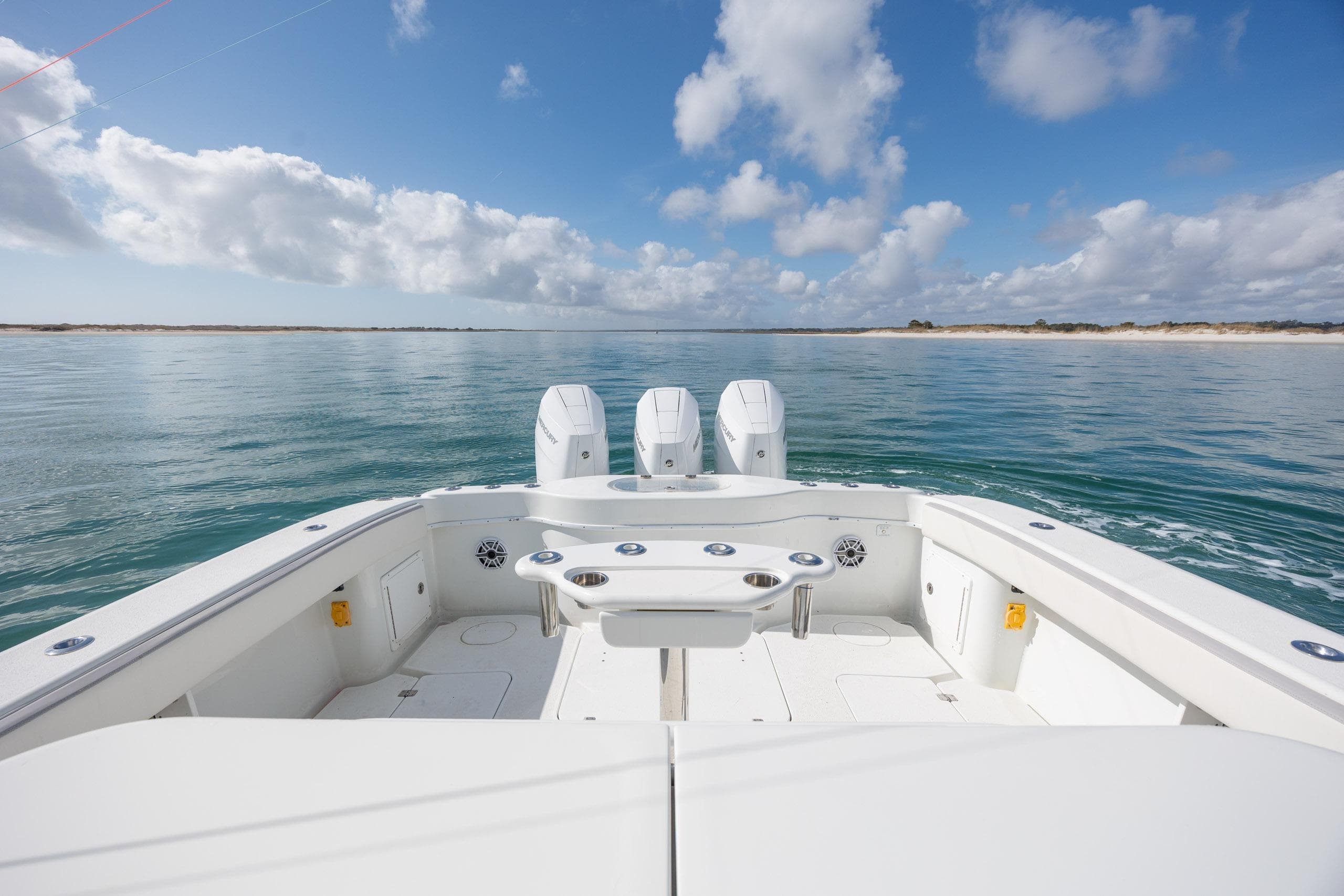 2014 Yellowfin 42 Offshore boat on calm sea under blue sky with clouds.