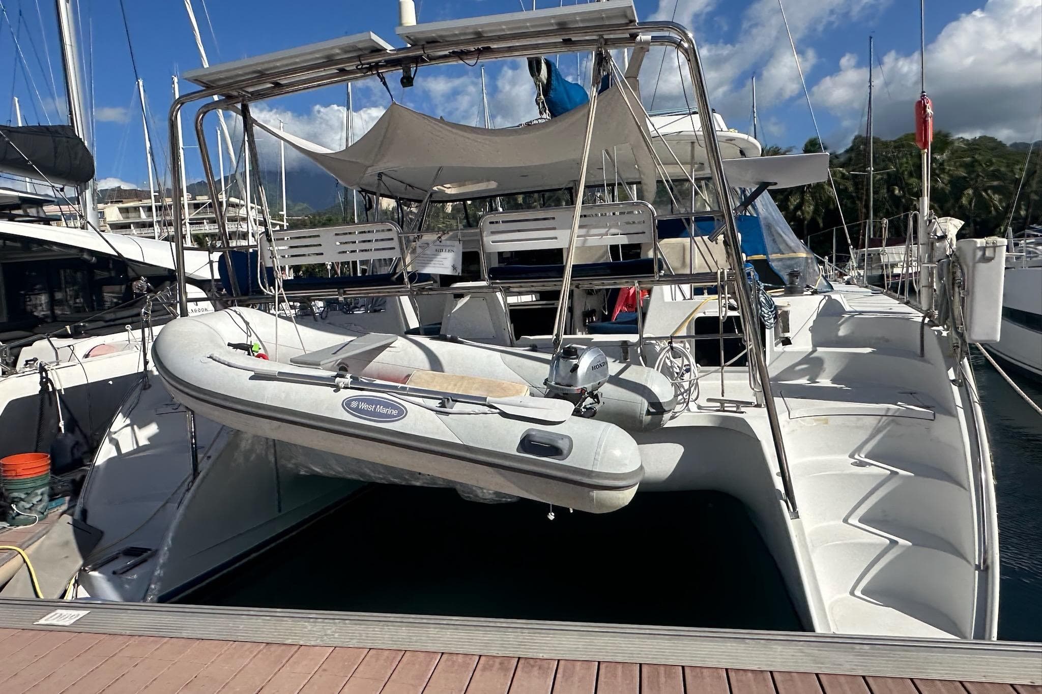 2002 PDQ Antares yacht docked with inflatable boat on davits, under clear blue sky.