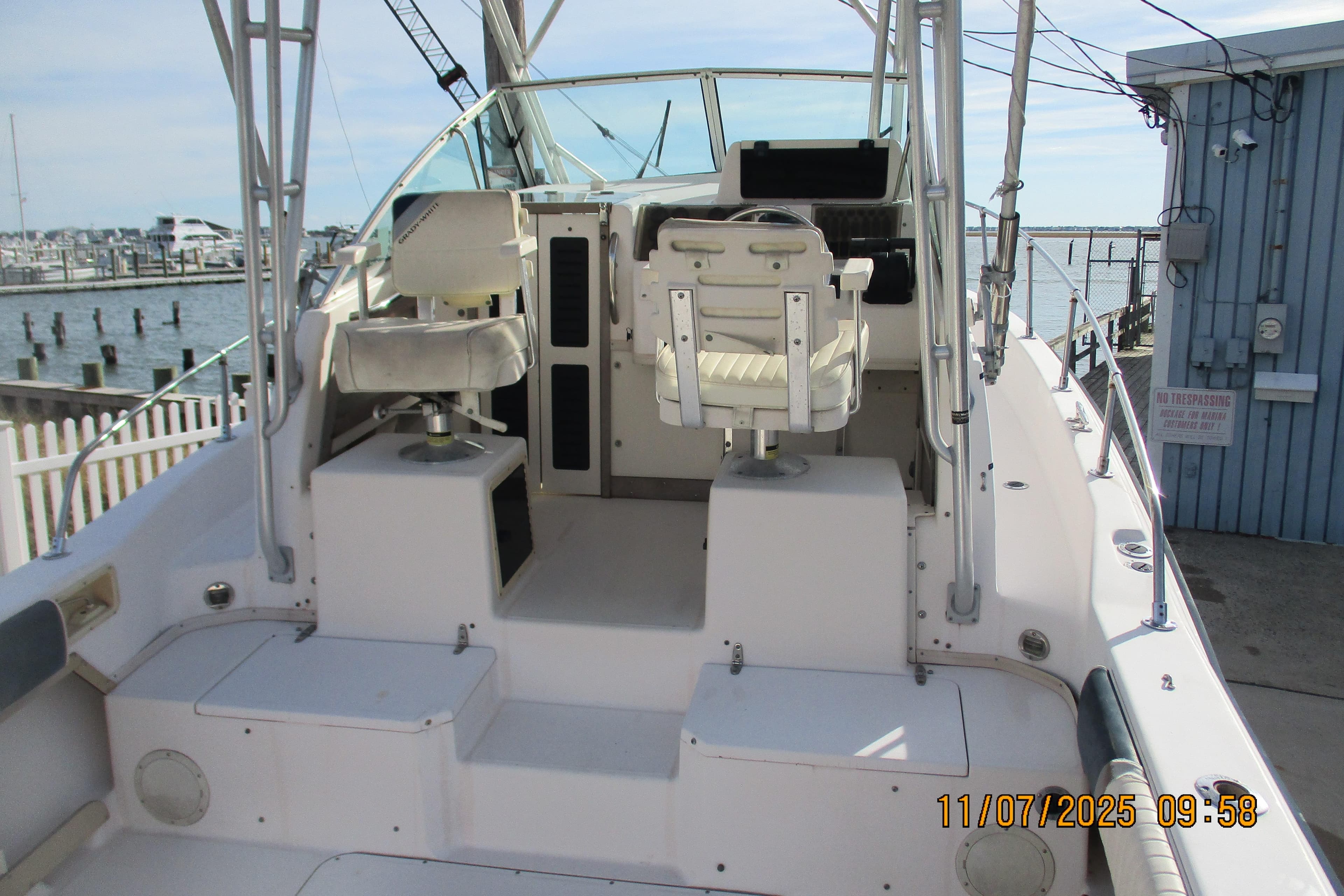 1996 Grady-White Sailfish 272 boat interior with helm and seating, docked by the marina.