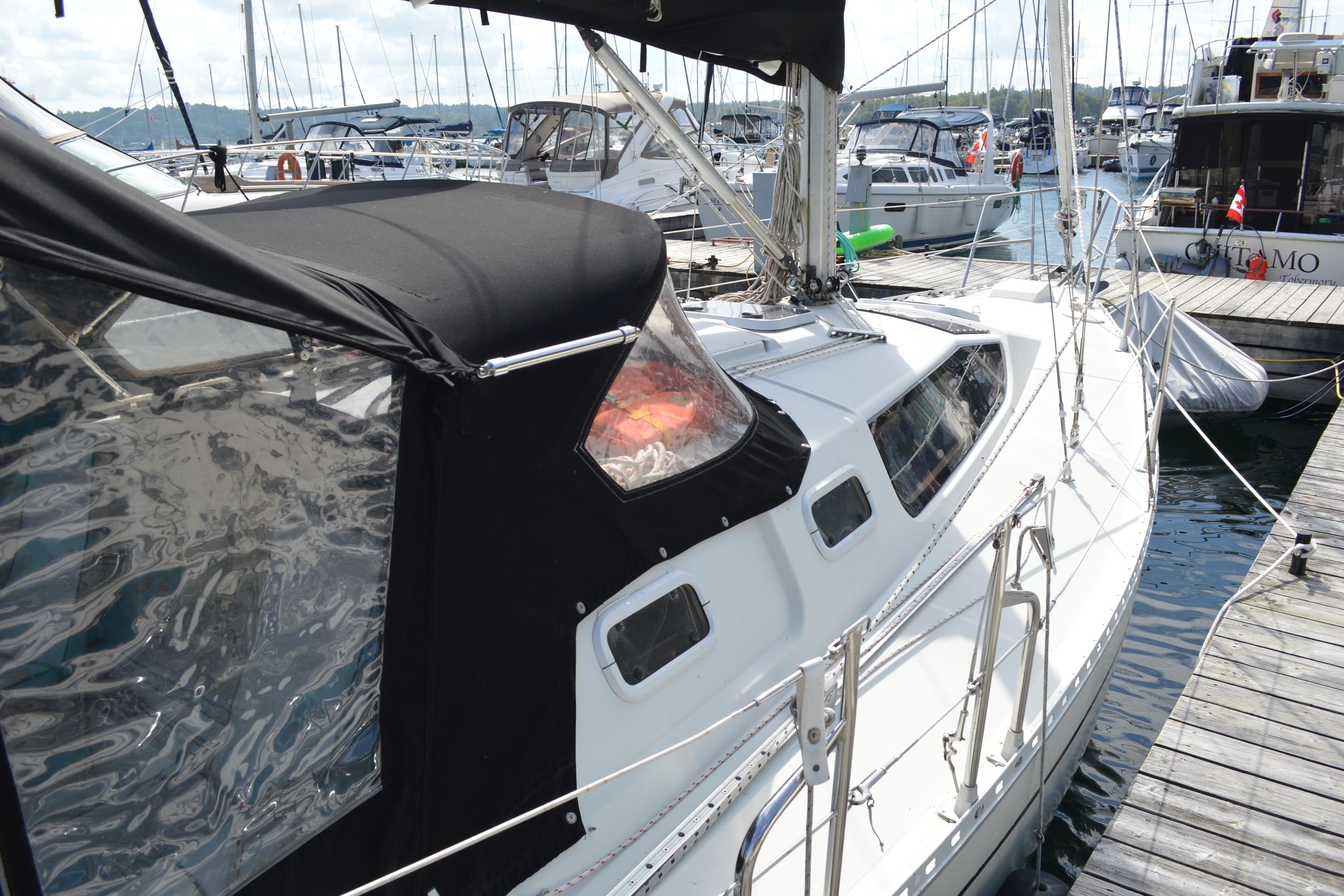 1989 Kirie Elite 326 sailboat docked at marina, featuring sleek design and black canopy.