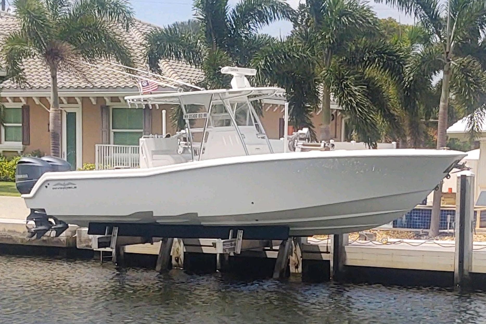 2017 Invincible 33 Open Fisherman boat docked by waterfront home.